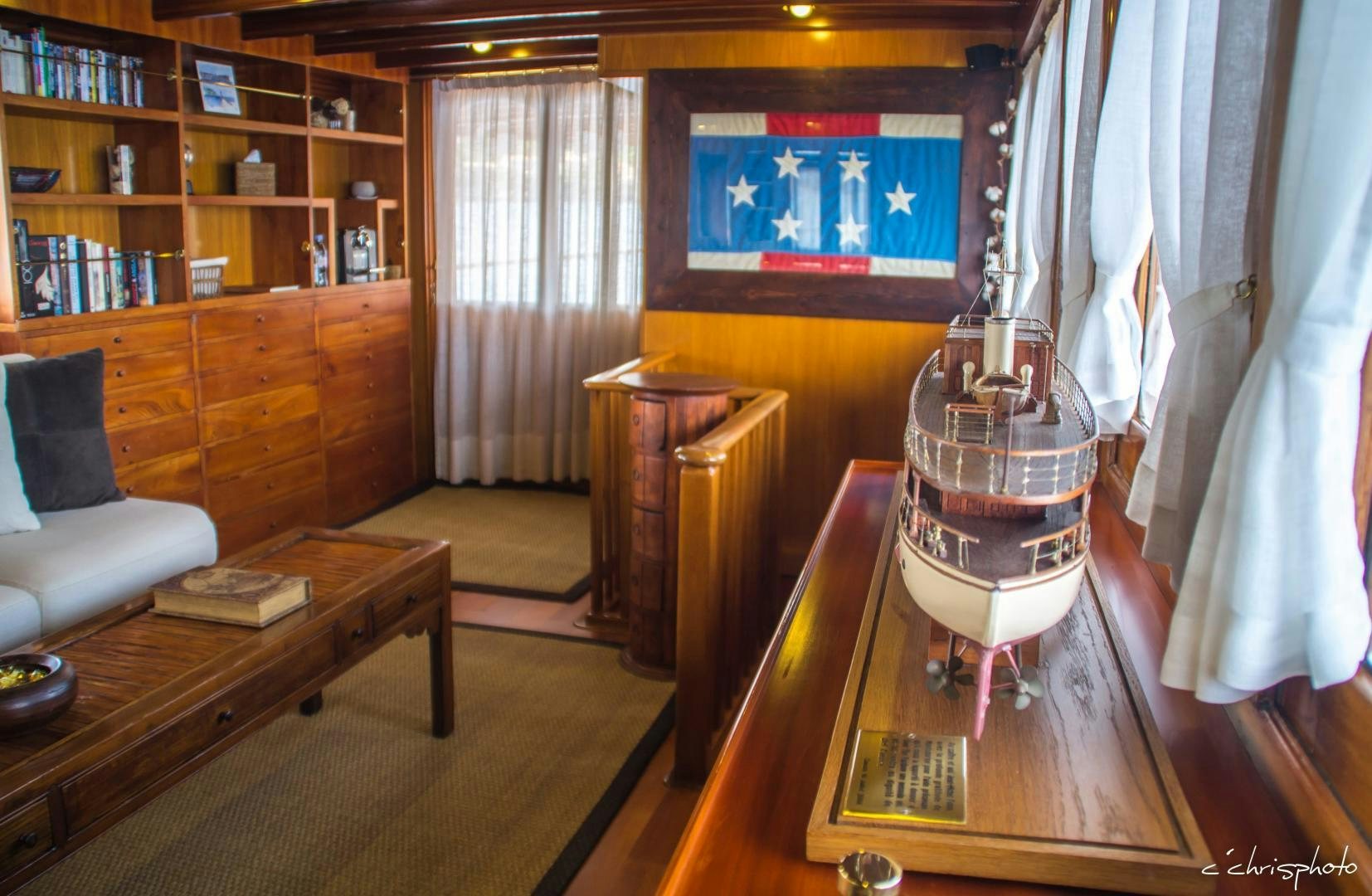 a room with a television and bookshelves aboard OVER THE RAINBOW OF LONDON Yacht for Sale