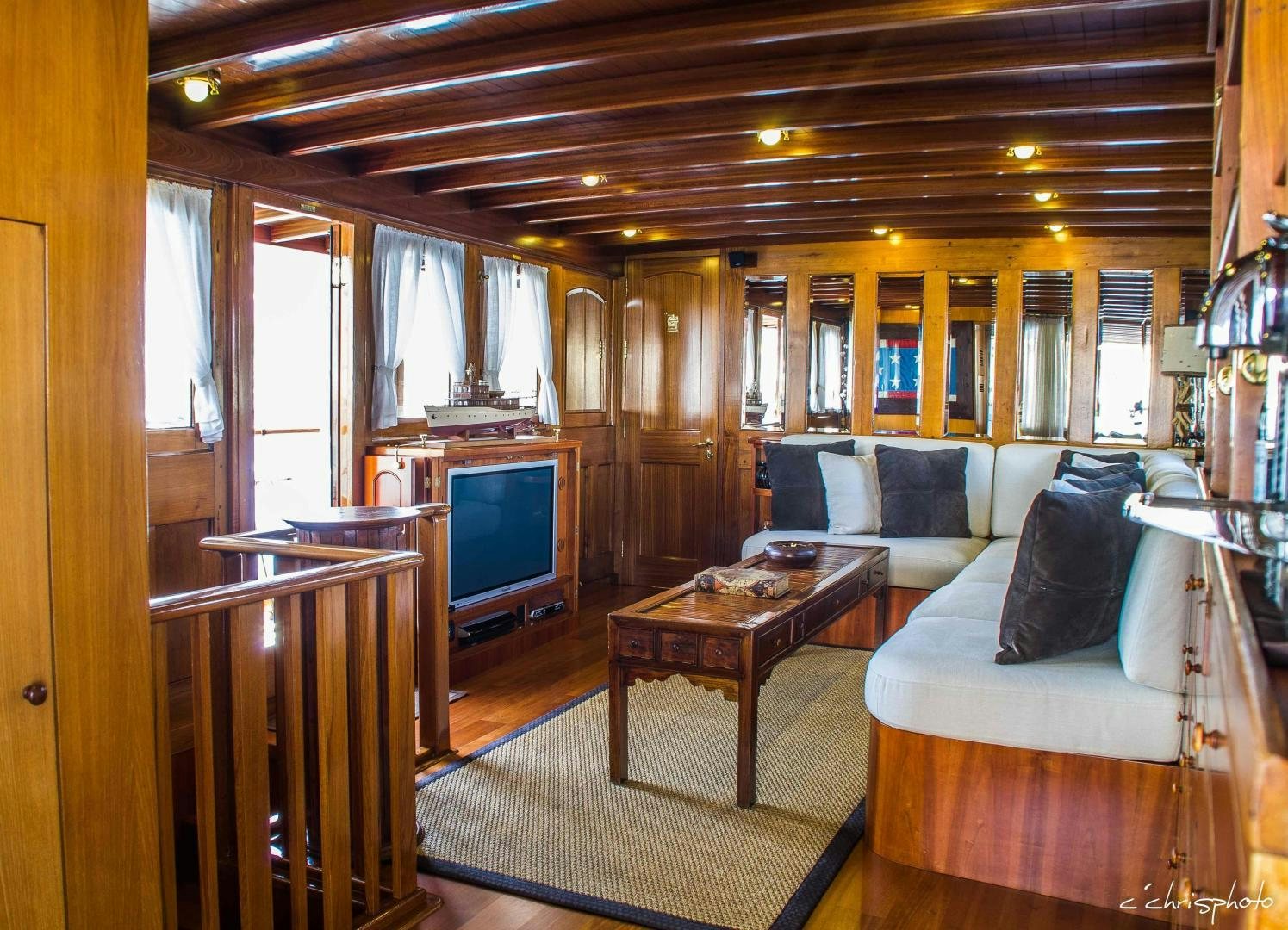 a living room with a couch and a television aboard OVER THE RAINBOW OF LONDON Yacht for Sale