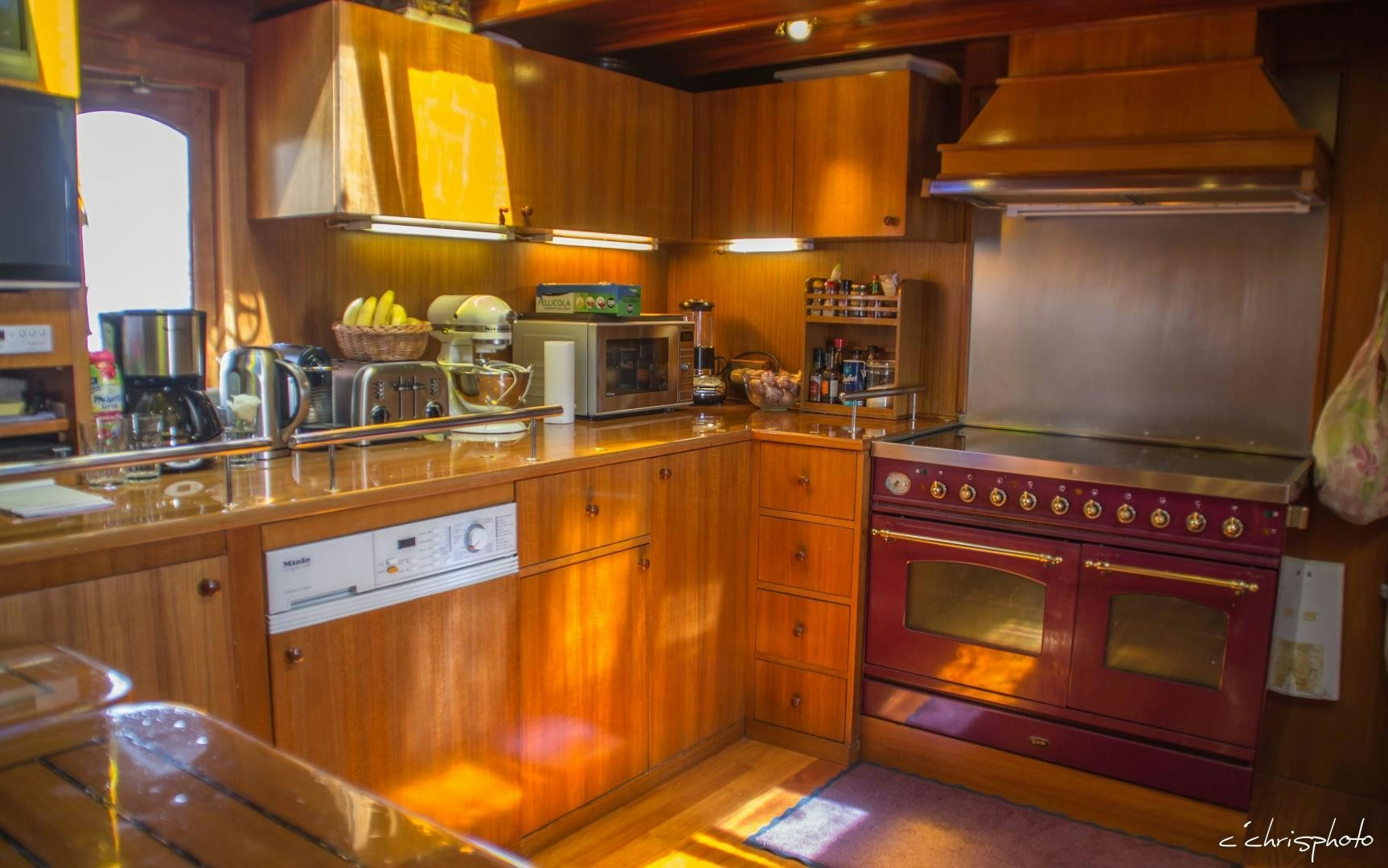a kitchen with wooden cabinets aboard OVER THE RAINBOW OF LONDON Yacht for Sale