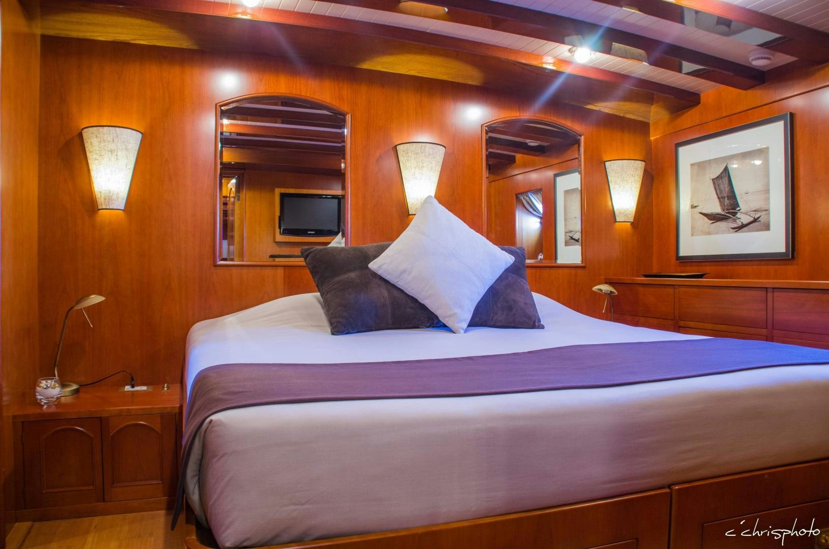 a bed with a blue and white bed spread aboard OVER THE RAINBOW OF LONDON Yacht for Sale