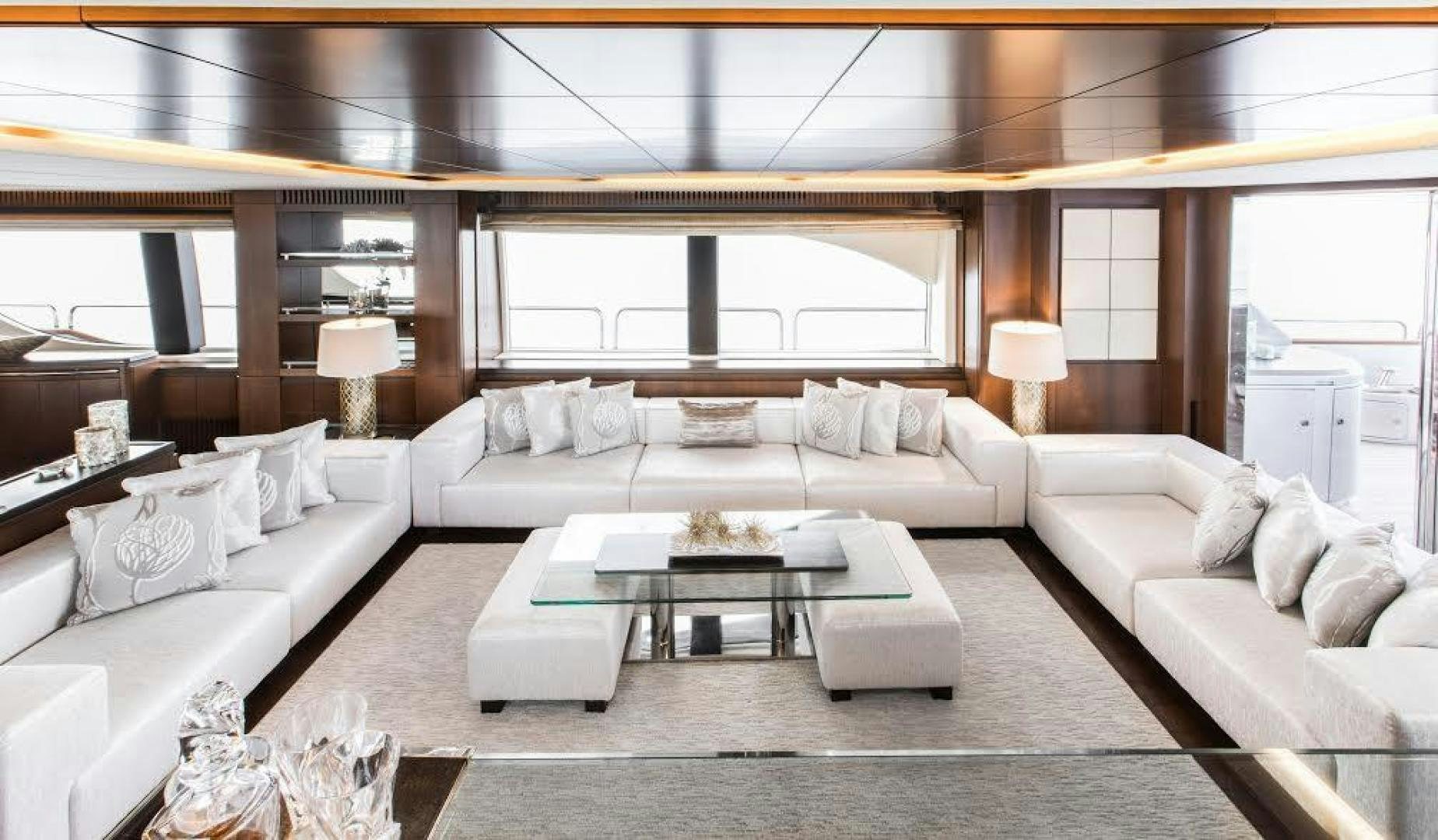 a living room with a large white couch and a large window aboard TAIL LIGHTS Yacht for Sale