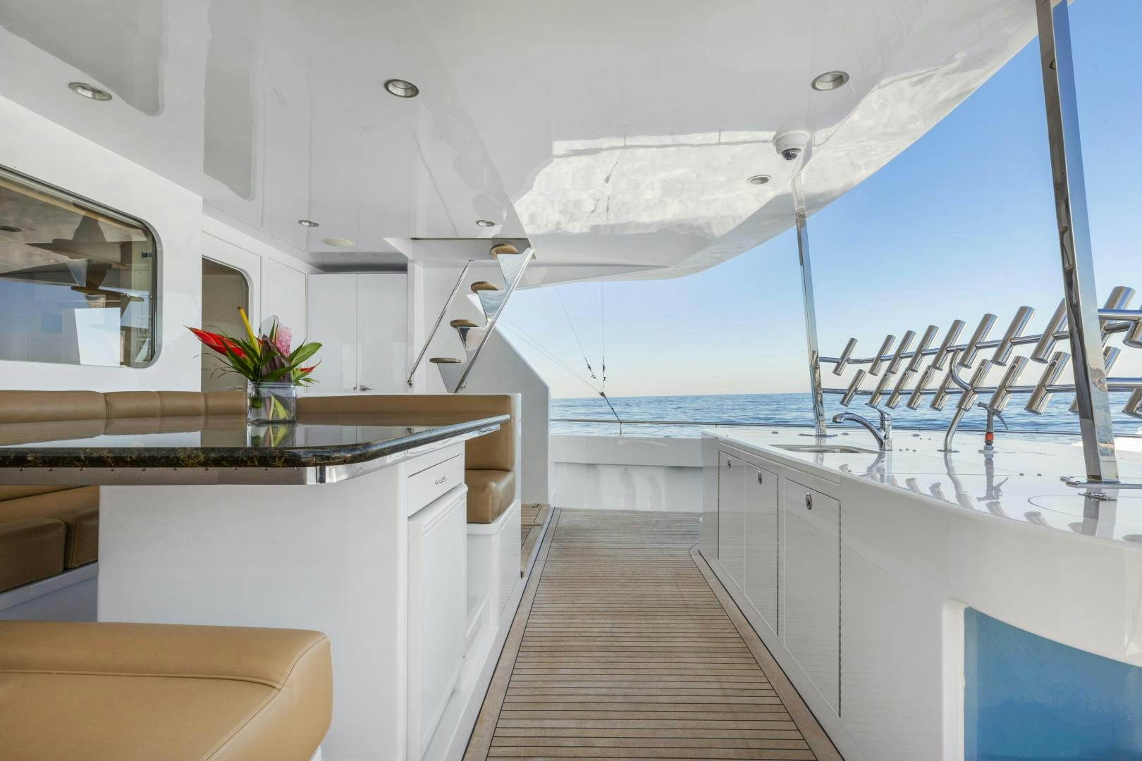 a white room with a wood floor and white cabinets and a plant on a sunny day aboard AQUILA Yacht for Sale