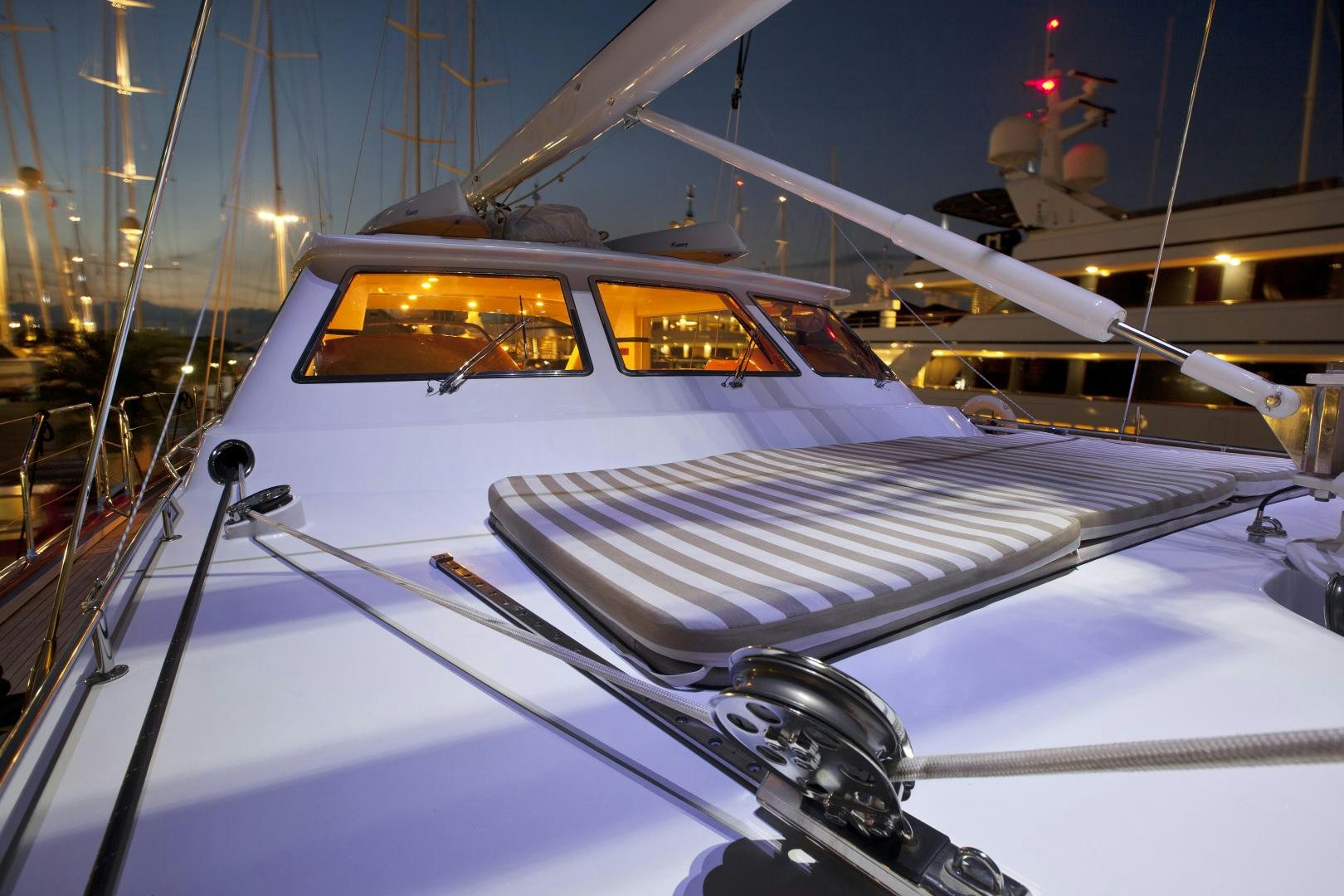 a white boat with a black and white striped front aboard REE Yacht for Sale