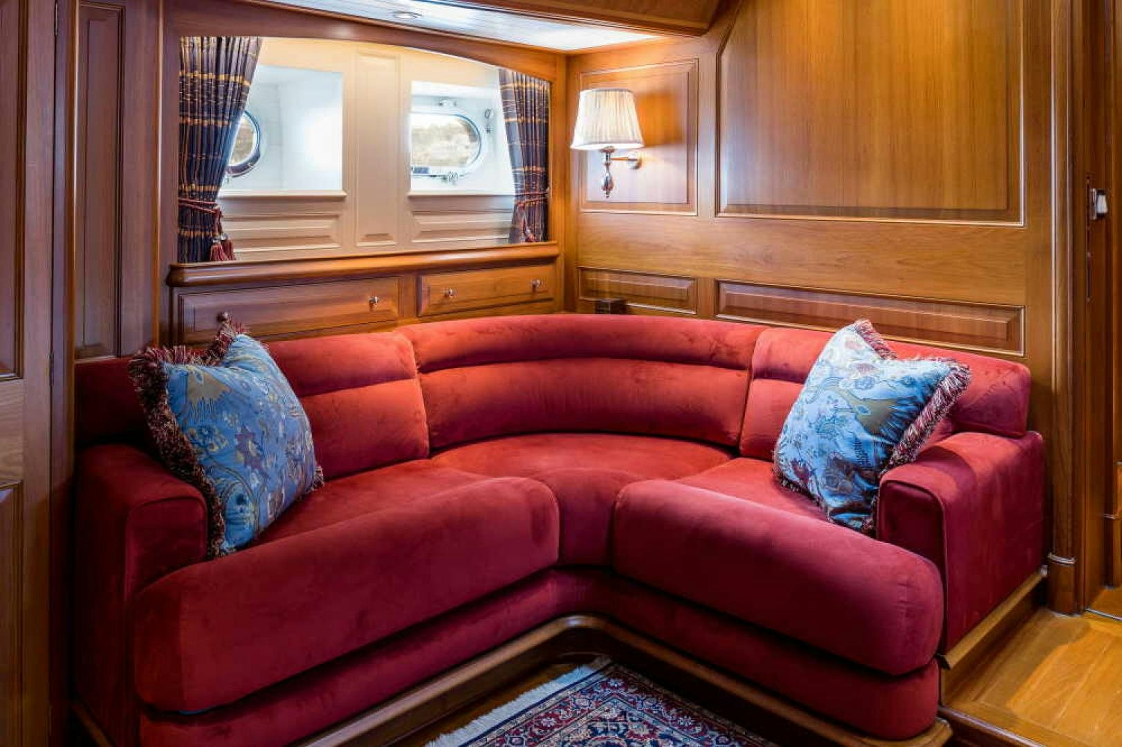 a red couch in a living room aboard BLUE TOO Yacht for Sale