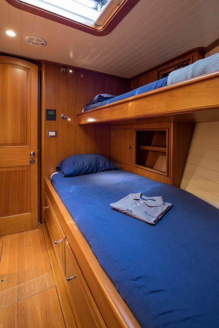 a bed with a blue comforter aboard BLUE TOO Yacht for Sale