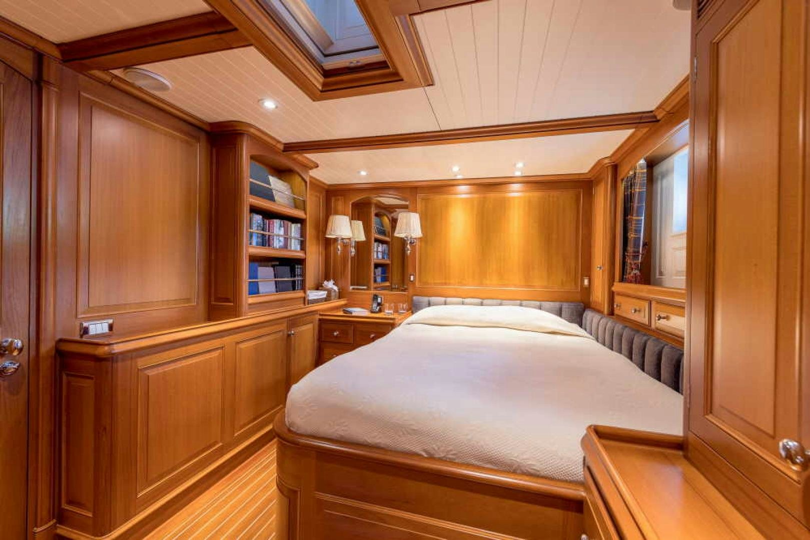 a bedroom with a bed and a bookcase aboard BLUE TOO Yacht for Sale