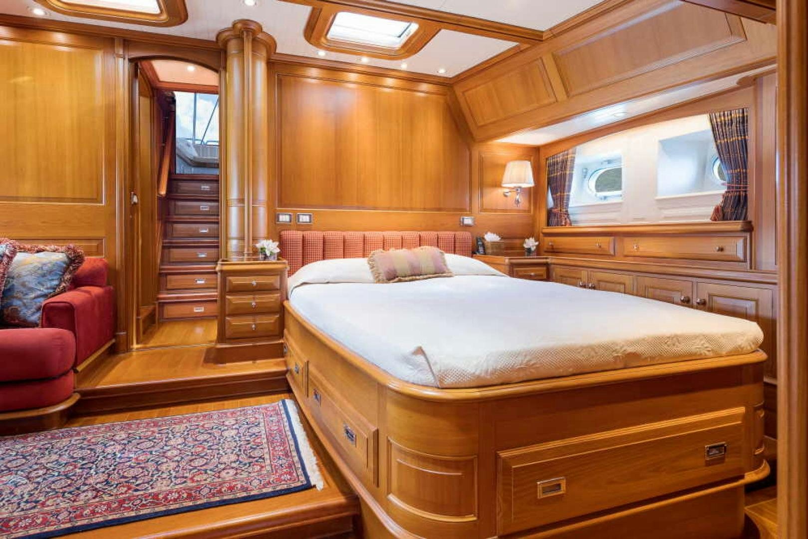 a bedroom with a bed and a chair aboard BLUE TOO Yacht for Sale