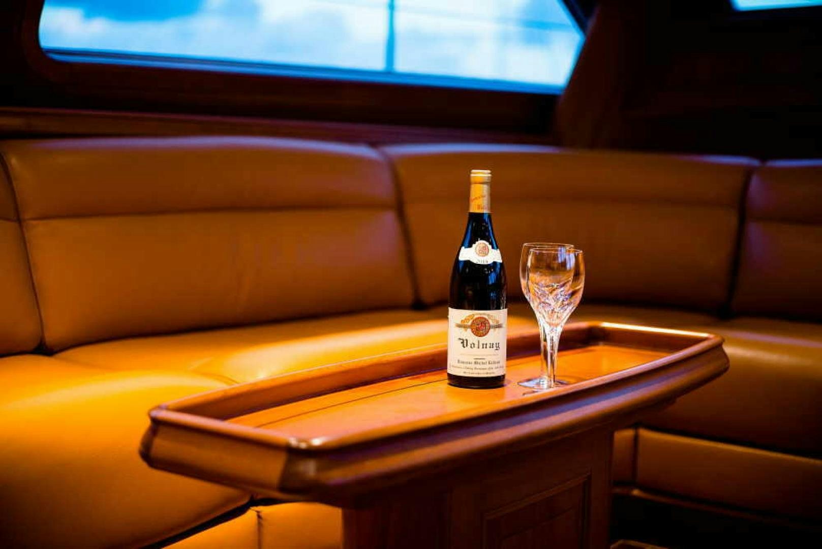 a bottle of wine and a glass on a table aboard BLUE TOO Yacht for Sale