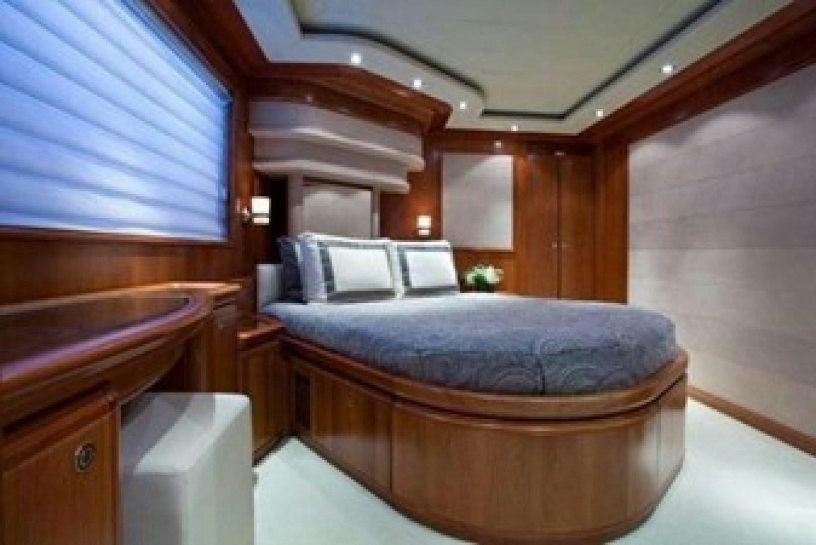 a bed with a blue sheet aboard MAMBO Yacht for Sale