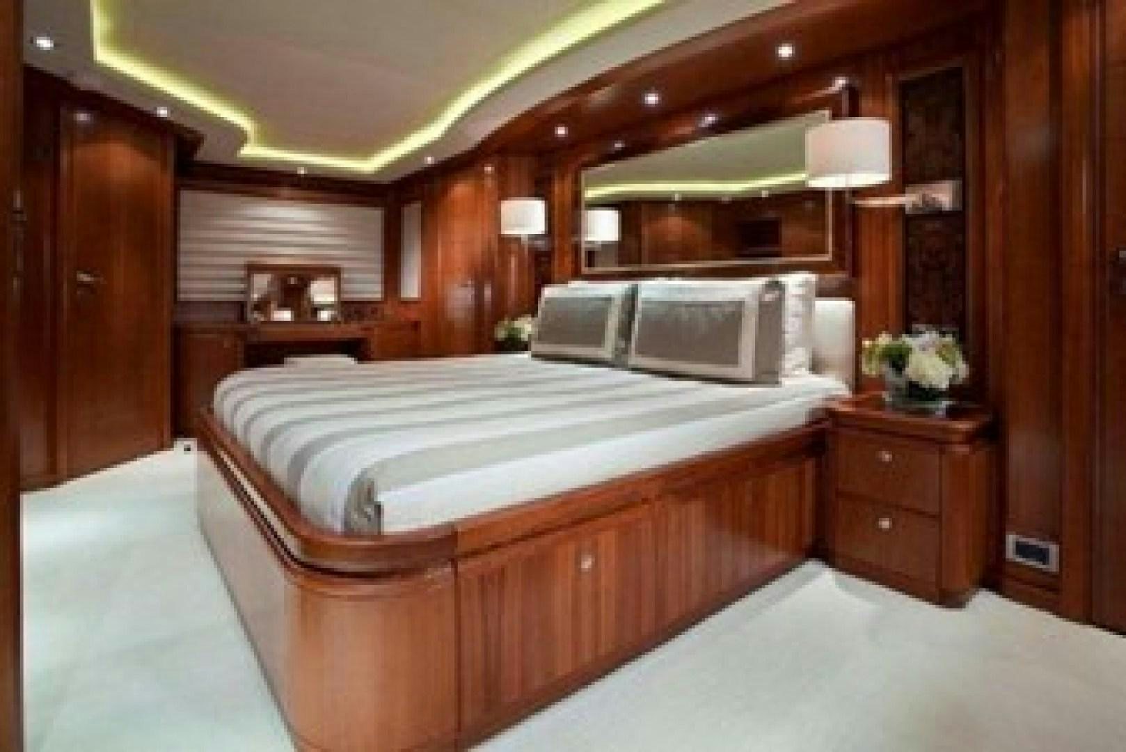 a bedroom with a bed and a mirror aboard MAMBO Yacht for Sale