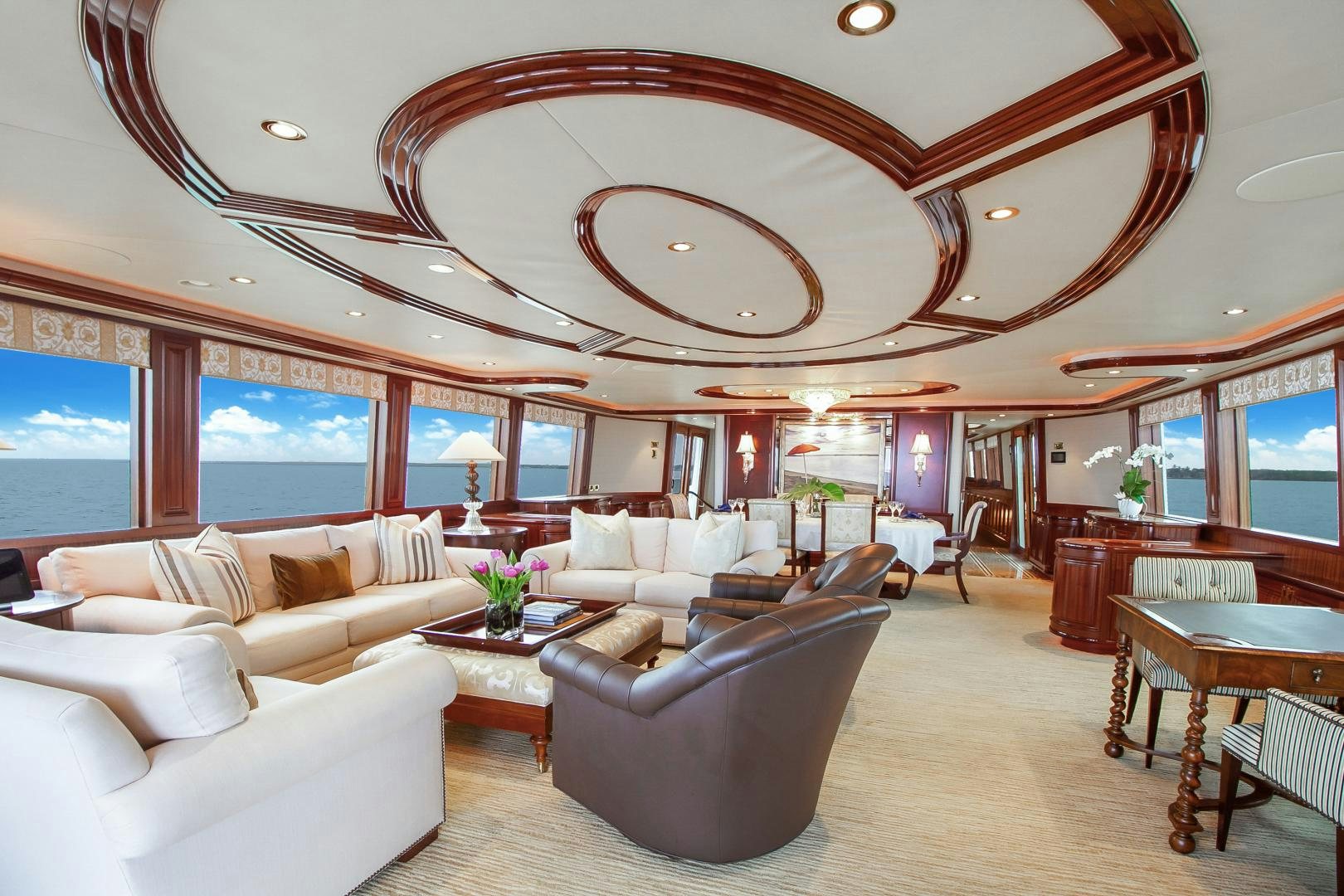 a large living room with a large chandelier aboard NAUTI N' Yacht for Sale