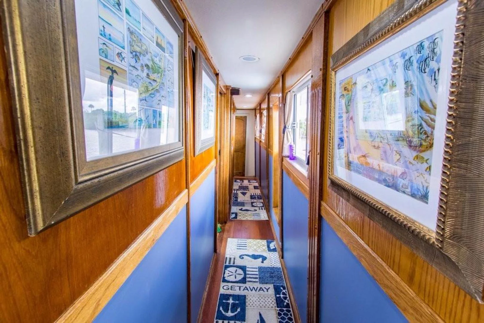 a hallway with paintings aboard TIMELESS Yacht for Sale