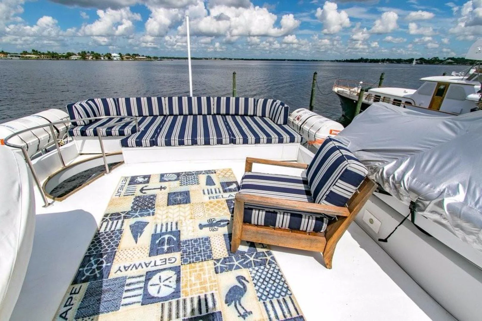 a deck with chairs and a table on it aboard TIMELESS Yacht for Sale