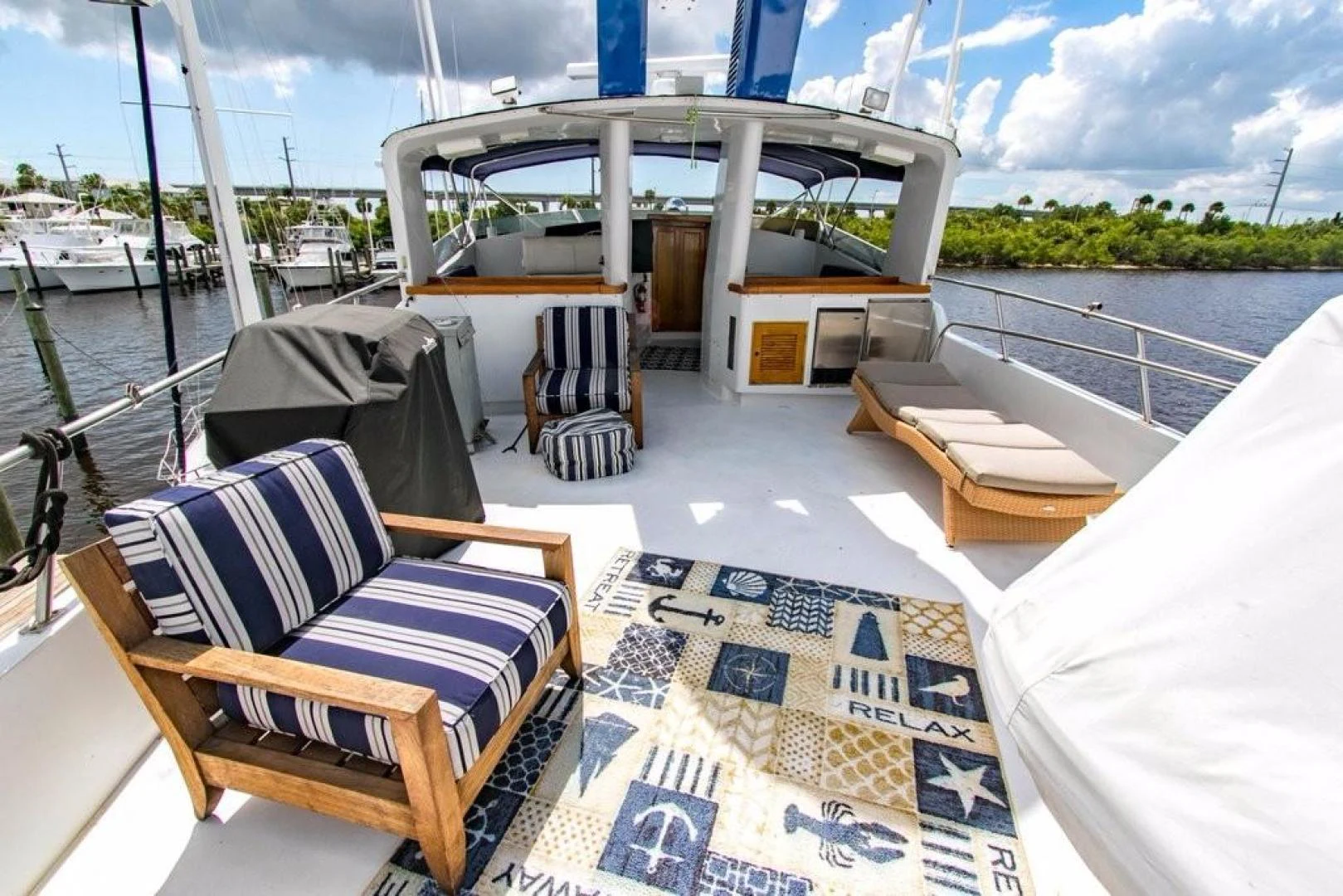 a deck with chairs and a table on it aboard TIMELESS Yacht for Sale