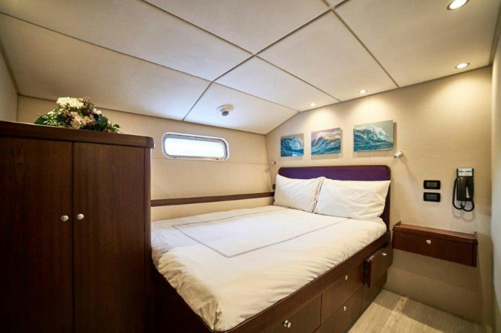 a bedroom with a bed and a dresser aboard ICEBERG Yacht for Sale