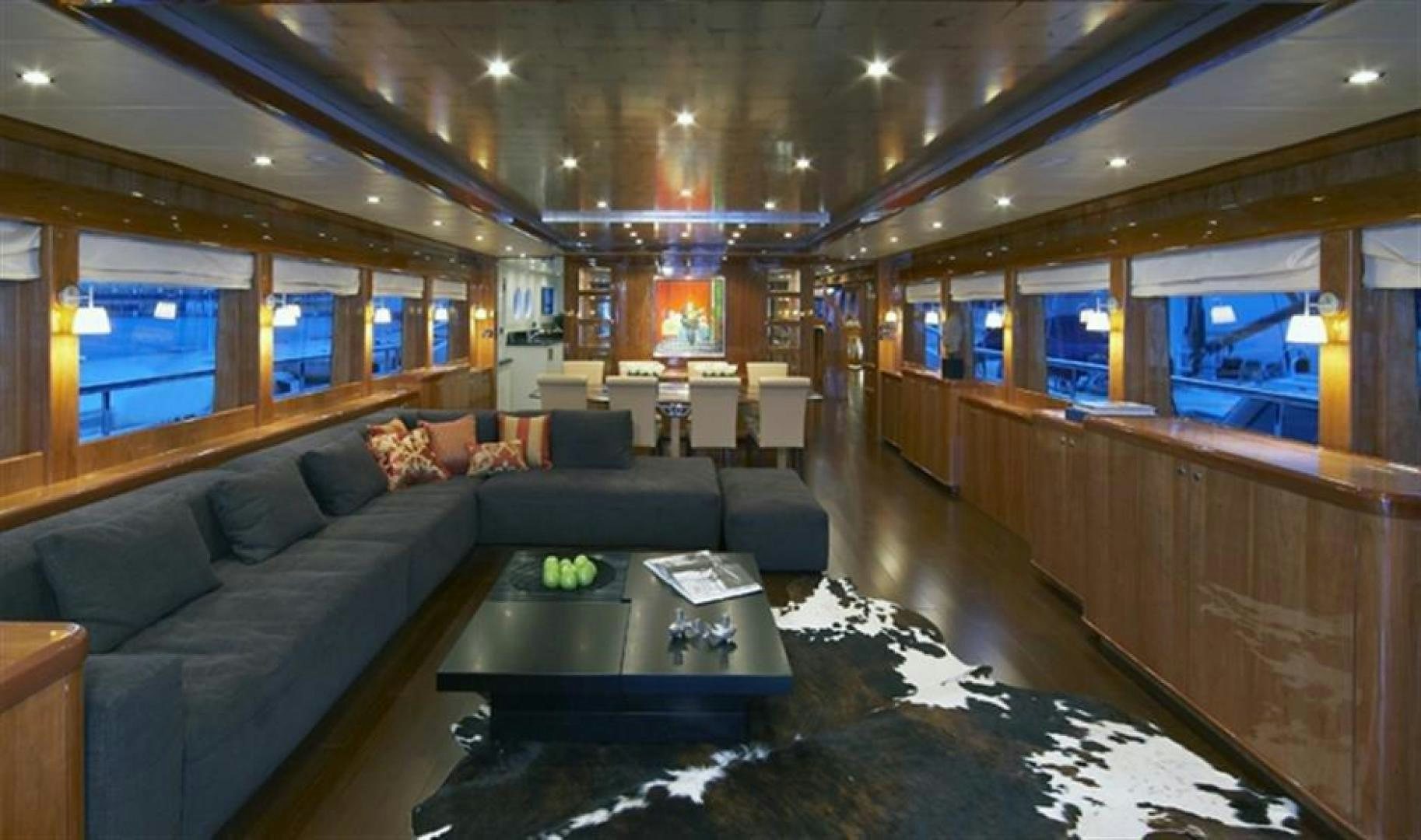 a living room with a large couch and a coffee table aboard JOHNSON 110 FLYBRIDGE Yacht for Charter
