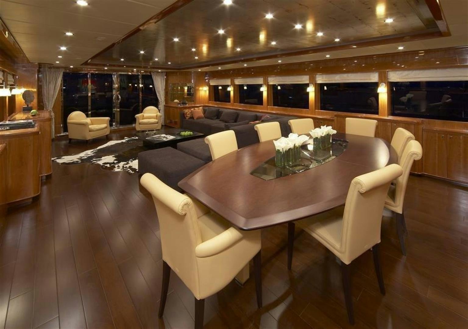 a large room with a table and chairs aboard JOHNSON 110 FLYBRIDGE Yacht for Charter