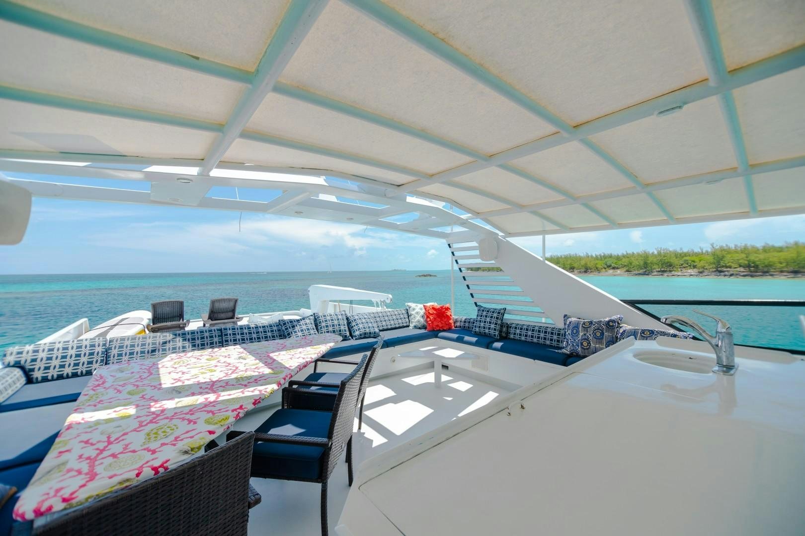 a deck with a table and chairs on it aboard ISLAND TIME Yacht for Sale