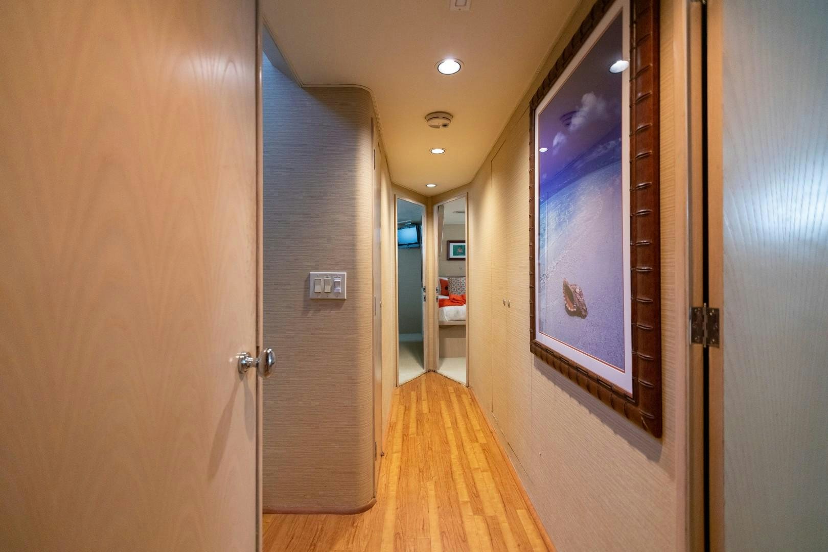 a hallway with a door and a painting on the wall aboard ISLAND TIME Yacht for Sale