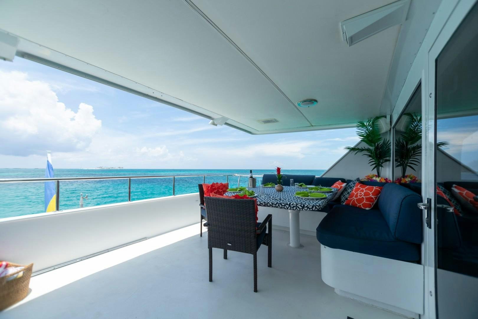 a table and chairs on a balcony aboard ISLAND TIME Yacht for Sale