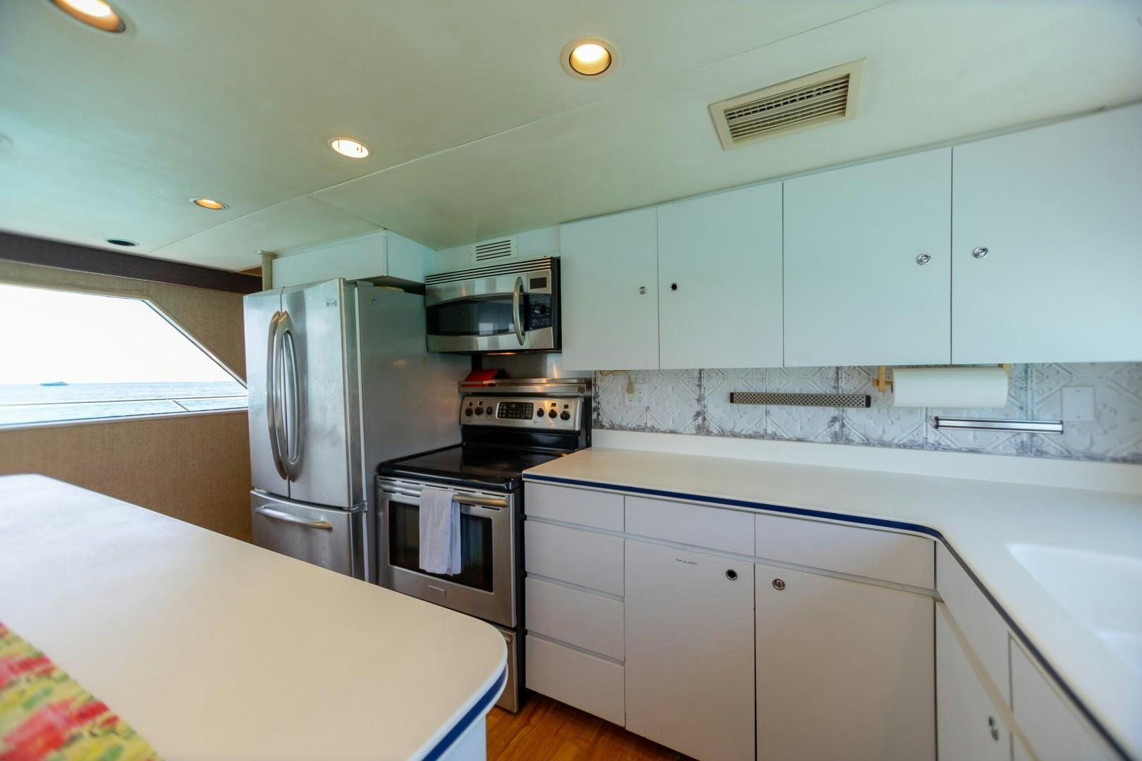 a kitchen with white cabinets aboard ISLAND TIME Yacht for Sale