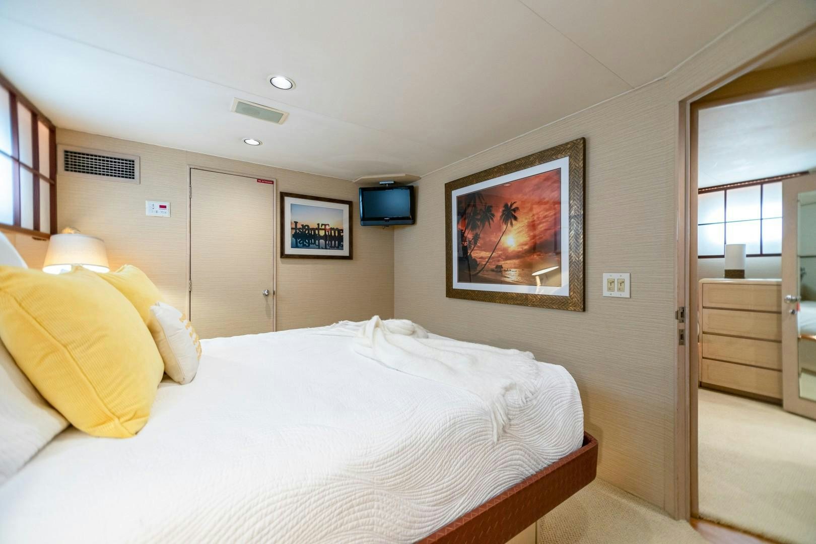 a bedroom with a bed and a television on the wall aboard ISLAND TIME Yacht for Sale