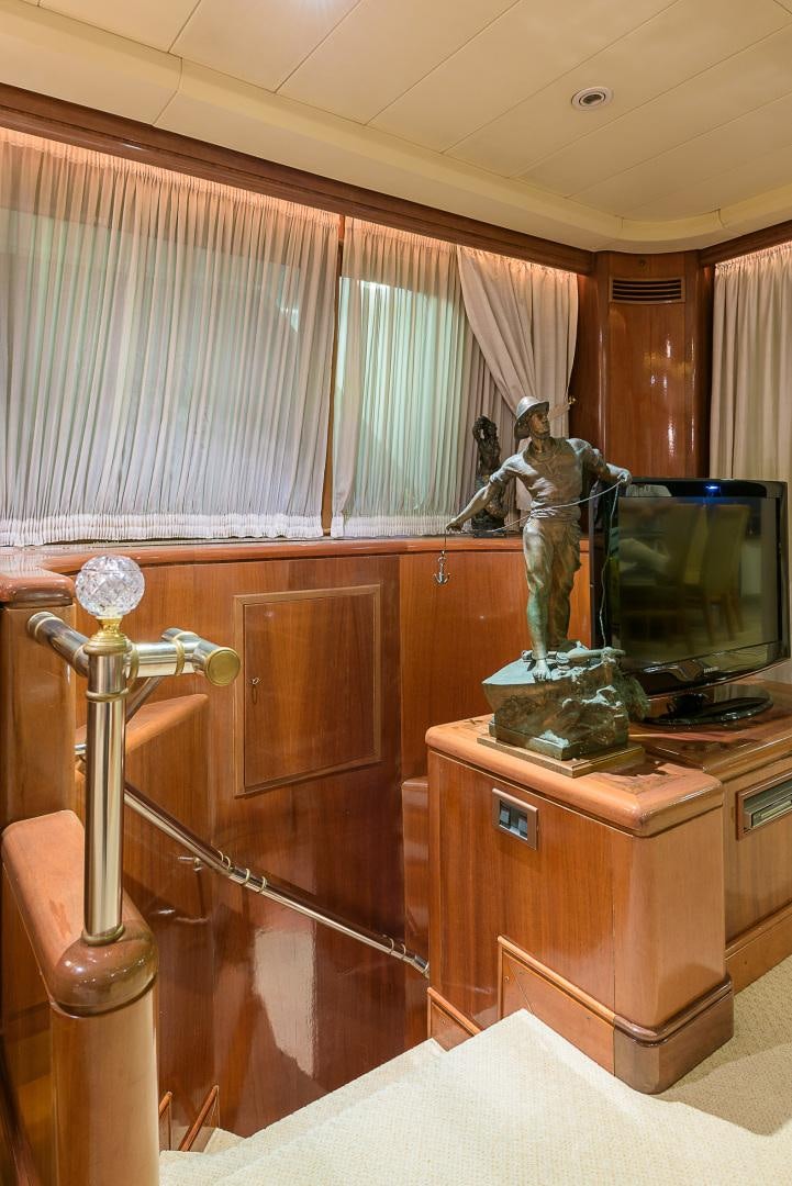a statue of a person in a room with a television and a lamp aboard ELBA Yacht for Sale