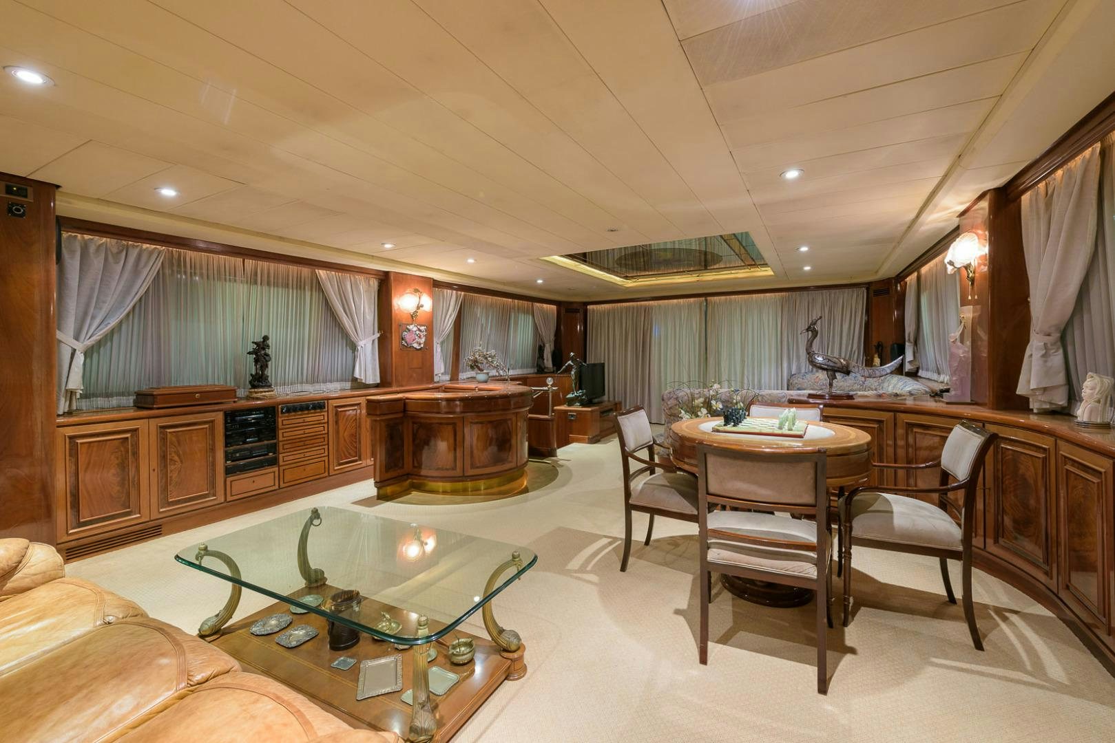 a large living room with a table and chairs aboard ELBA Yacht for Sale