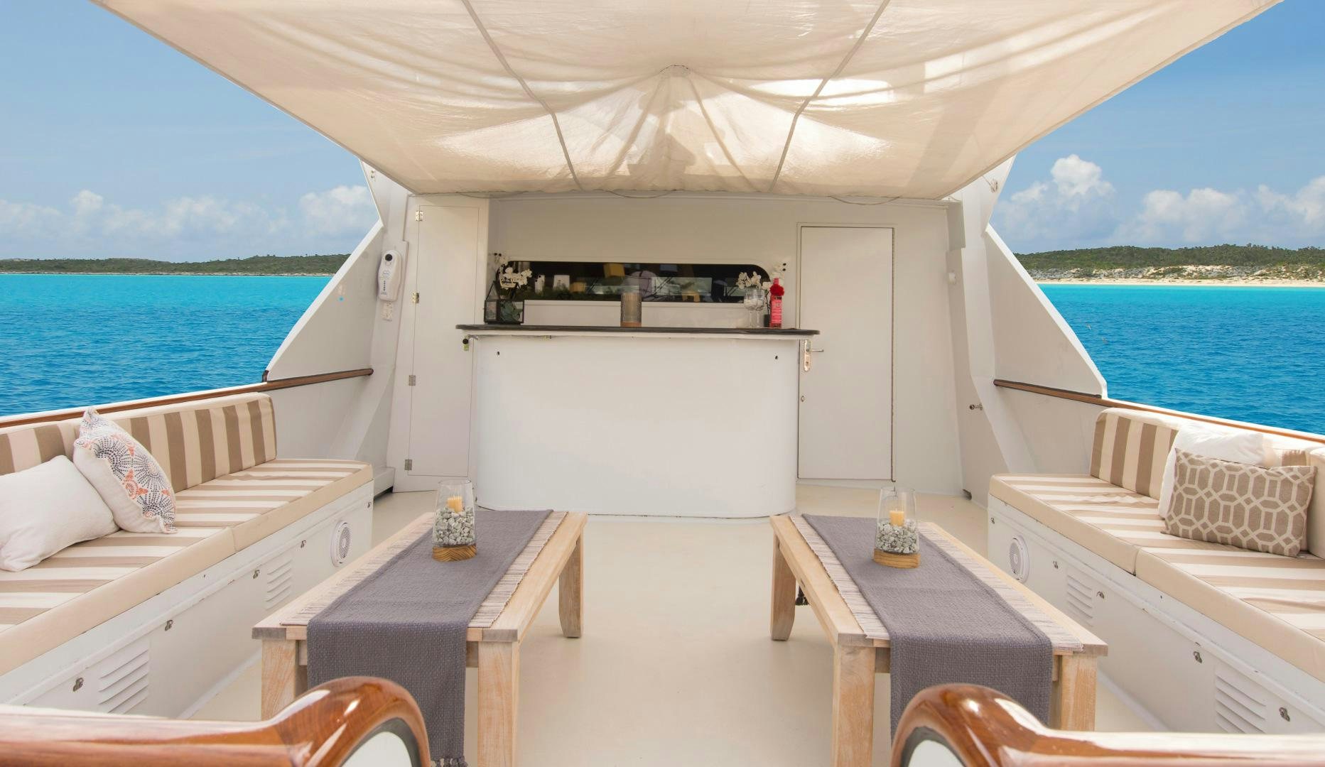 a room with a bed and a table and a view of the ocean aboard KALEEN Yacht for Sale