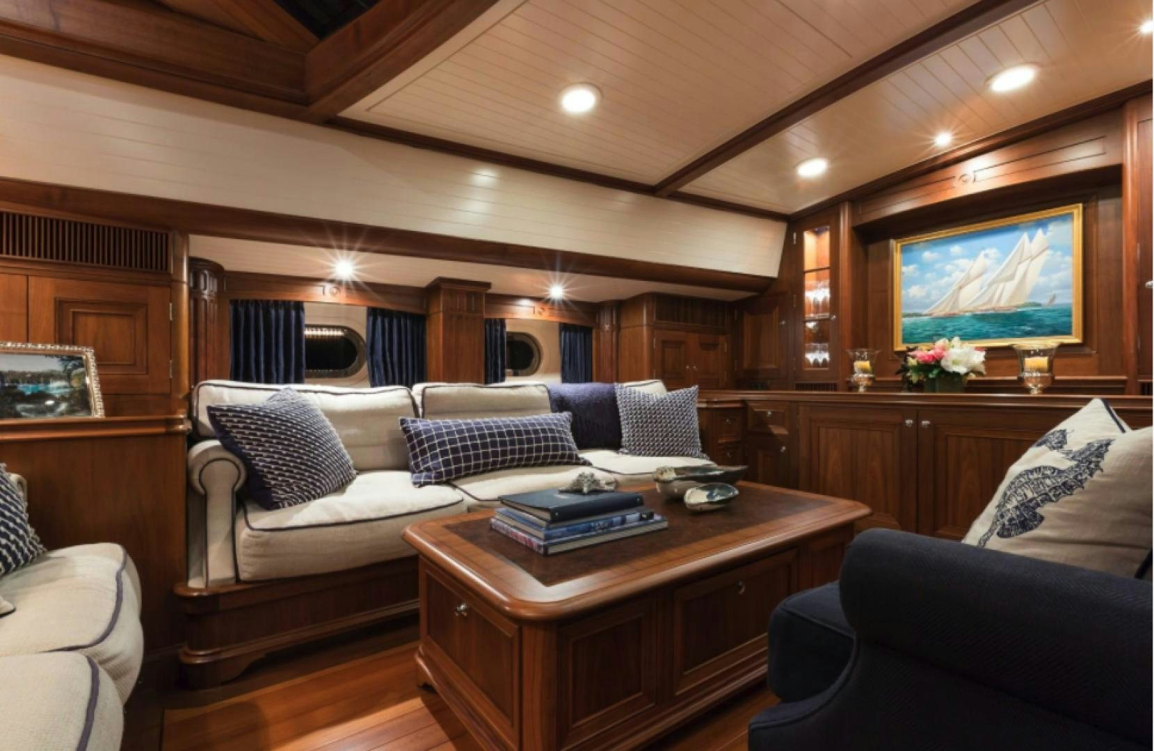 a living room with a tv and a table aboard MARAE Yacht for Sale