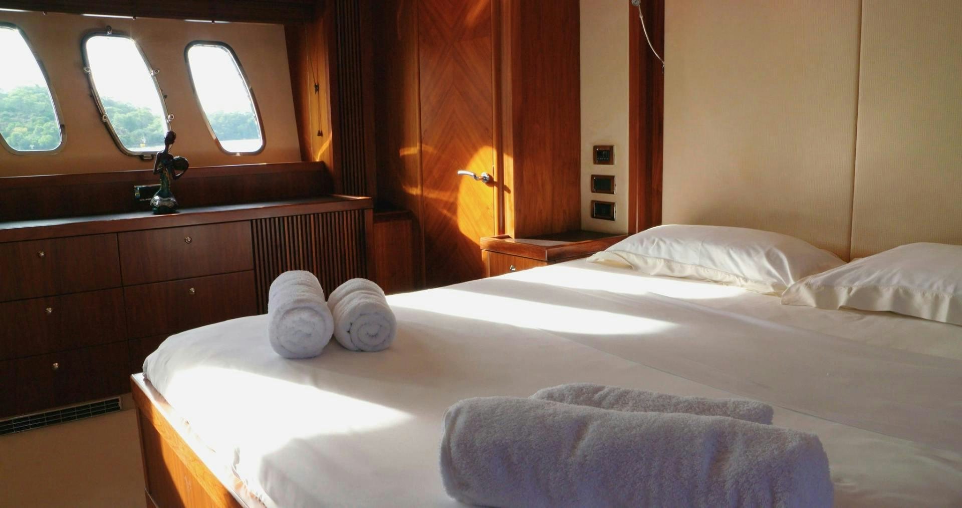 a bed with white sheets and pillows aboard LAURA S Yacht for Sale