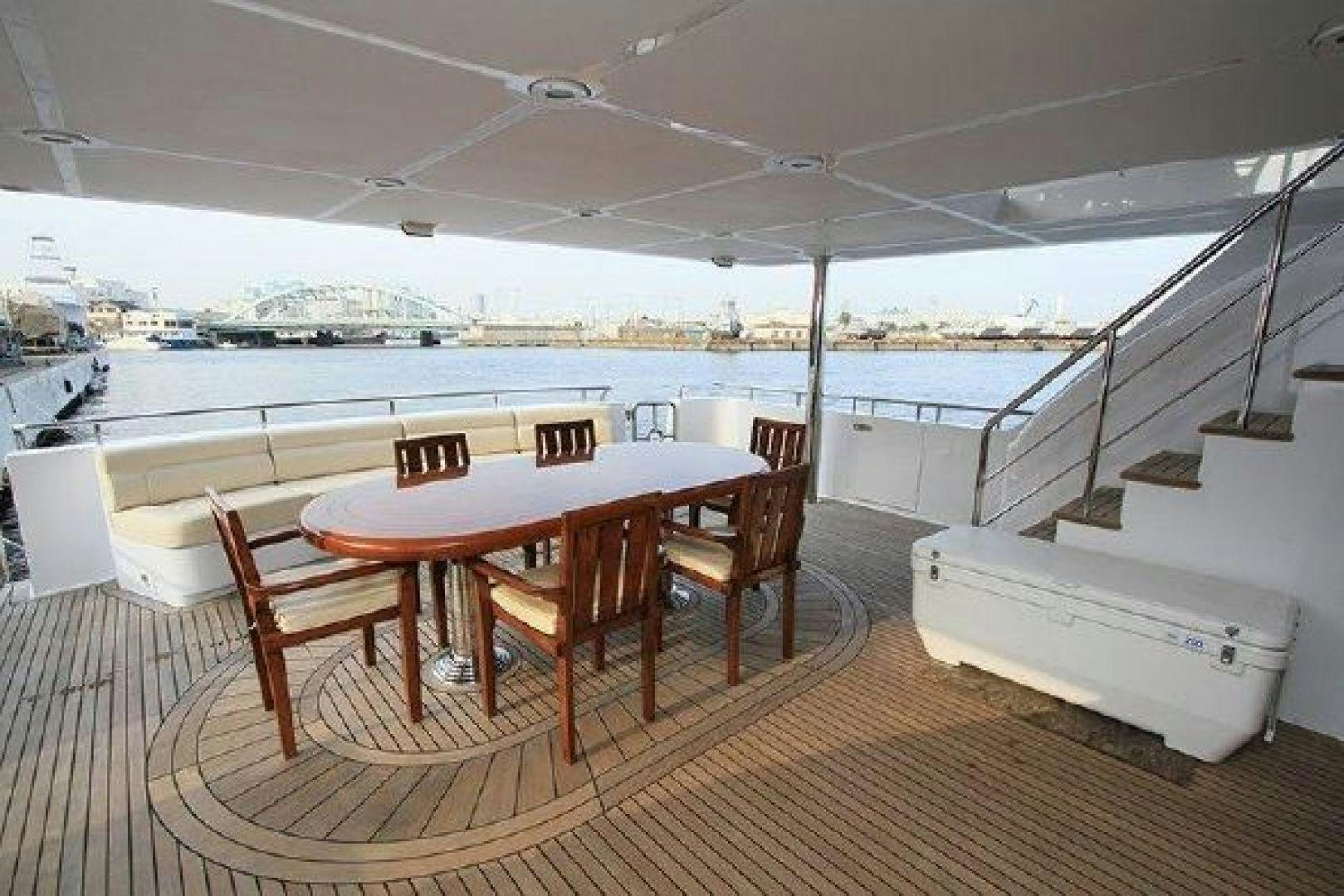 a table and chairs on a deck aboard WHITE LOTUS VIII Yacht for Sale