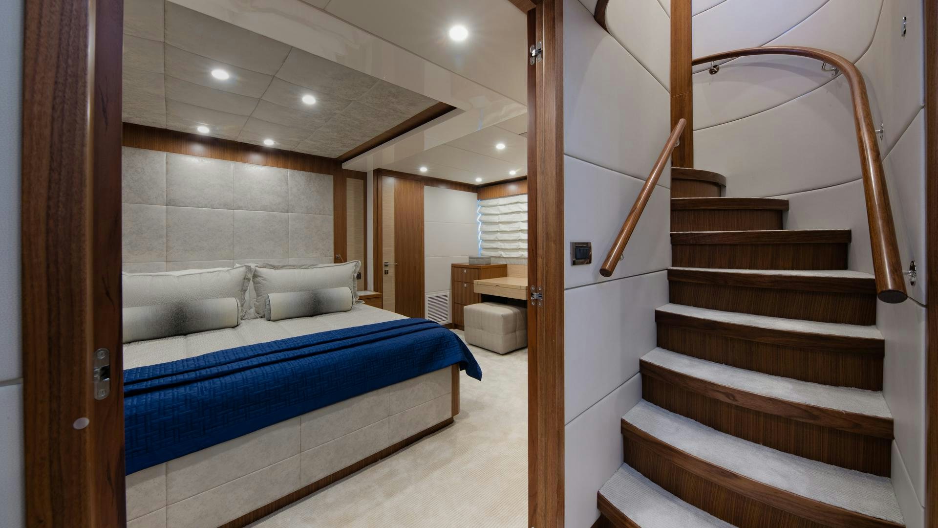 a modern looking bathroom with a blue tub and a wood staircase aboard RISK TAKER Yacht for Charter