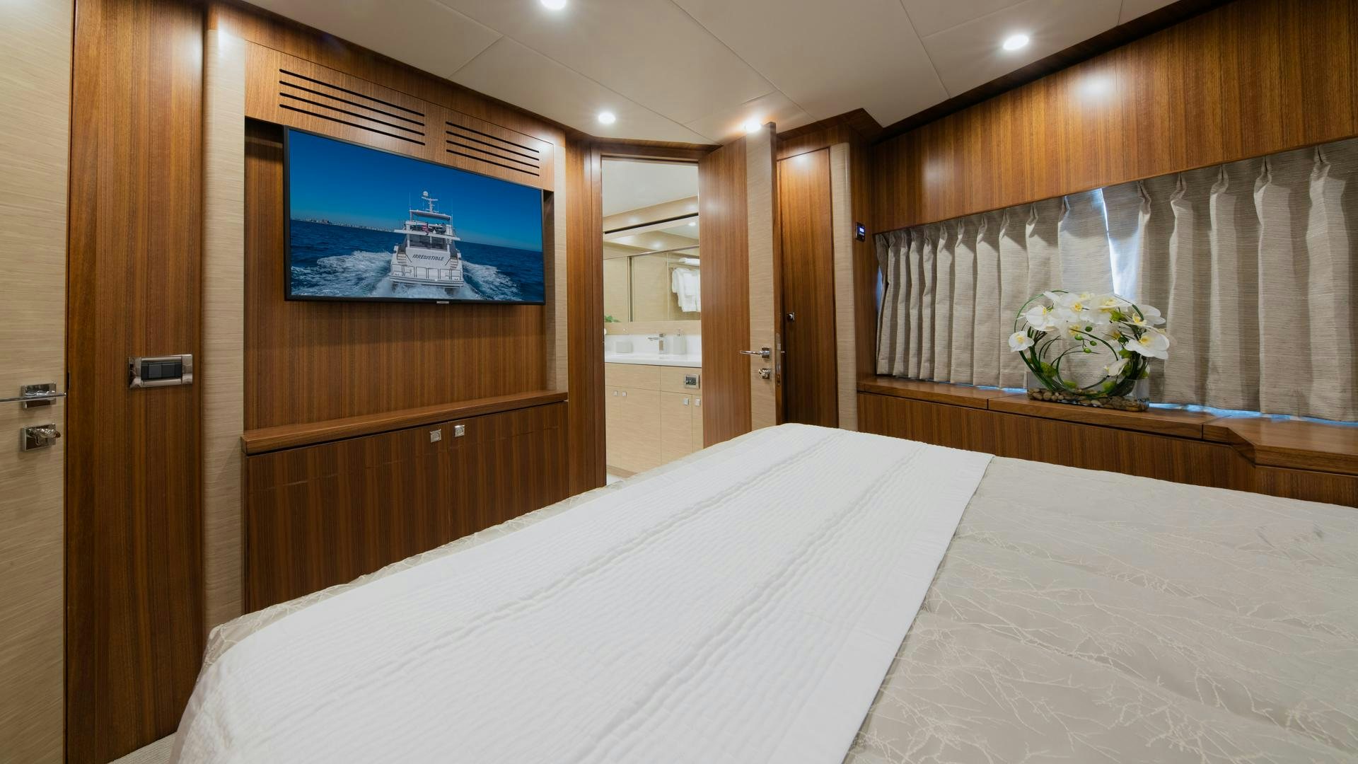 a hotel room with a bed and a television aboard RISK TAKER Yacht for Charter