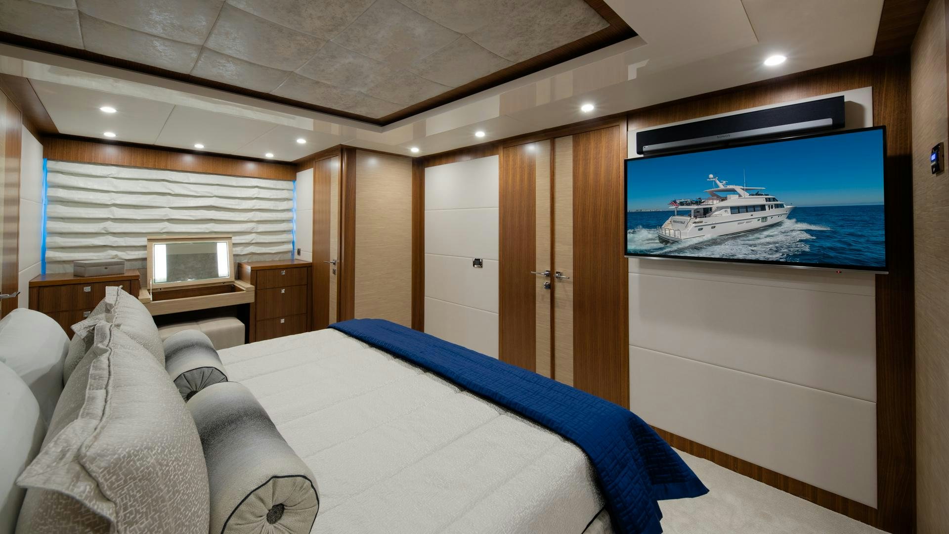 a bedroom with a bed and a television aboard RISK TAKER Yacht for Sale