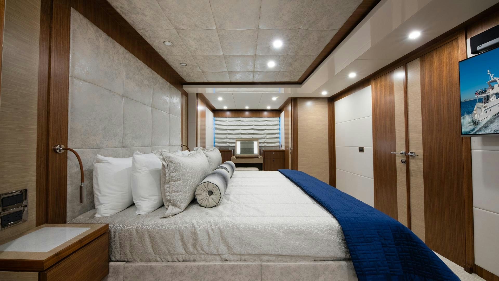 a bed with pillows and a television aboard RISK TAKER Yacht for Sale