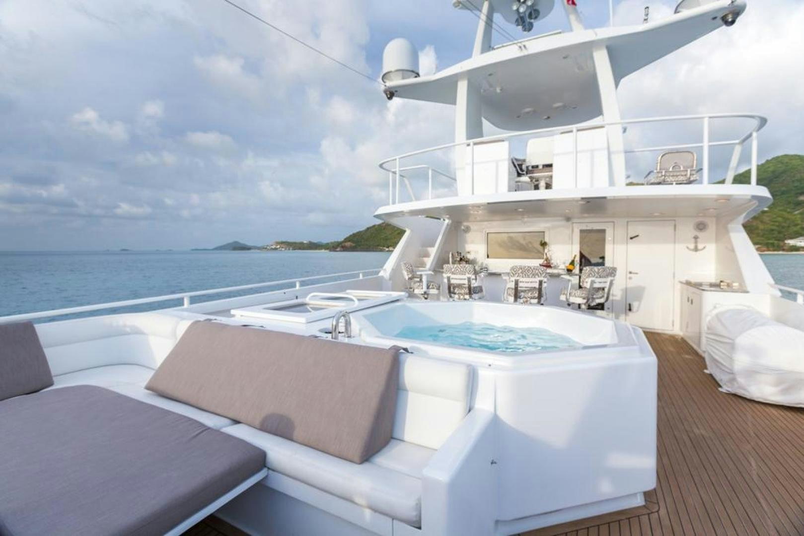 a large white lounge chair on a deck overlooking a large body of water aboard PIRATE RADIO Yacht for Sale