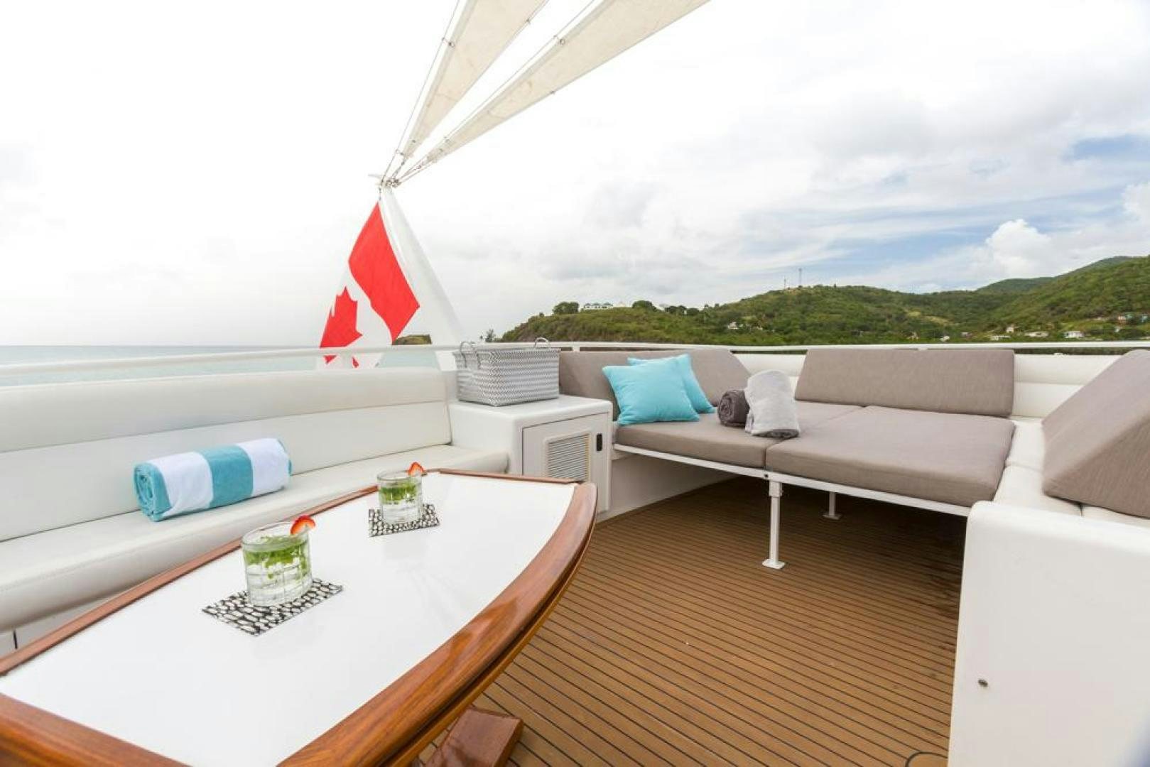 a room with a couch and a table with a flag on it aboard PIRATE RADIO Yacht for Sale
