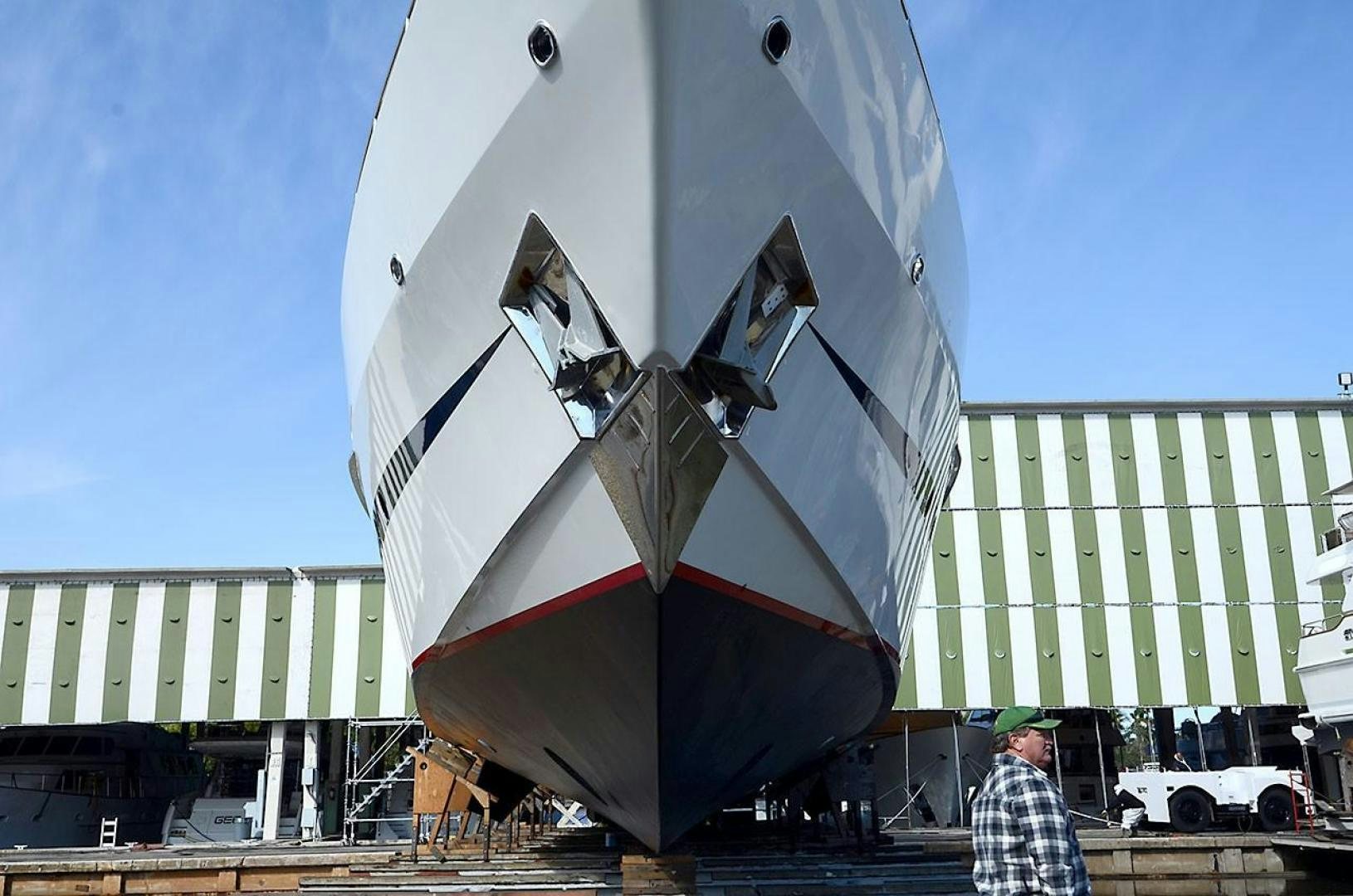 a person standing next to a large sailboat aboard LADY ARLENE Yacht for Sale