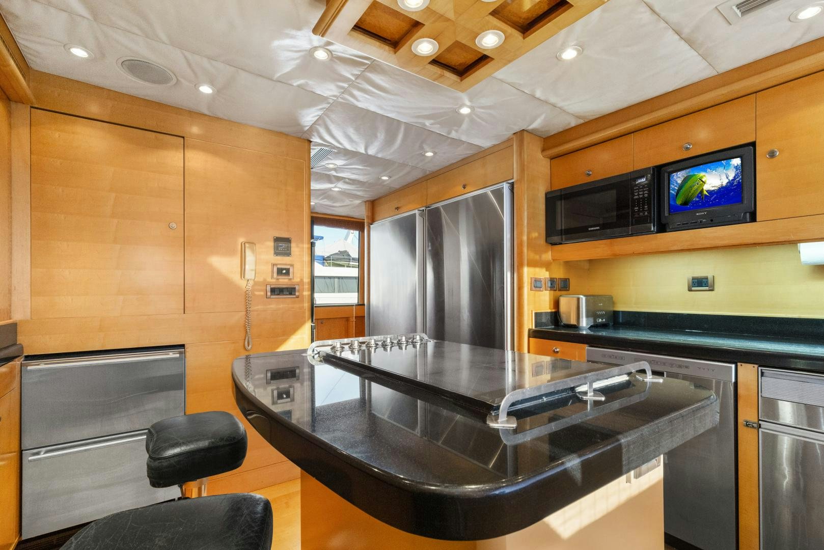 a kitchen with a large bar and a tv on the wall aboard ILLEAGLE Yacht for Sale