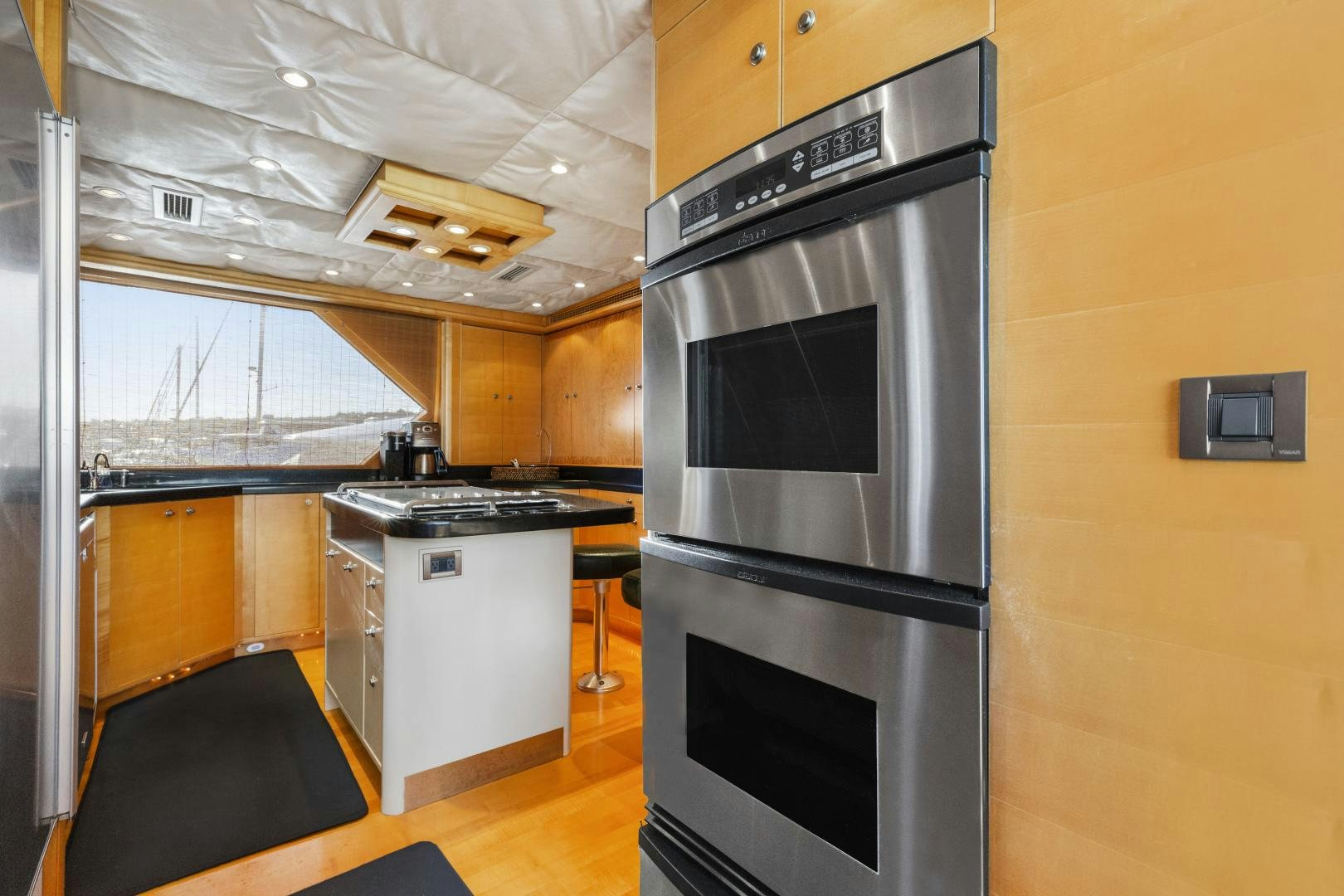 a kitchen with a large stainless steel oven and a black table aboard ILLEAGLE Yacht for Sale