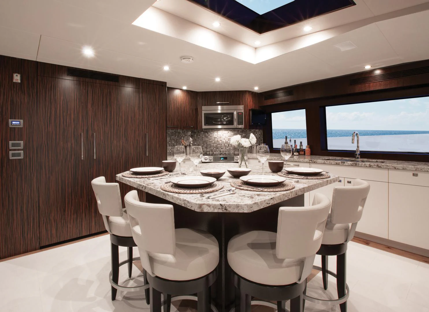 a kitchen with a table and chairs aboard 2021 HATTERAS 105RPH Yacht for Sale