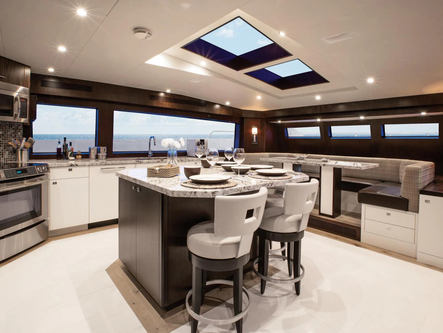 a large kitchen with a large island aboard 2021 HATTERAS 105RPH Yacht for Sale