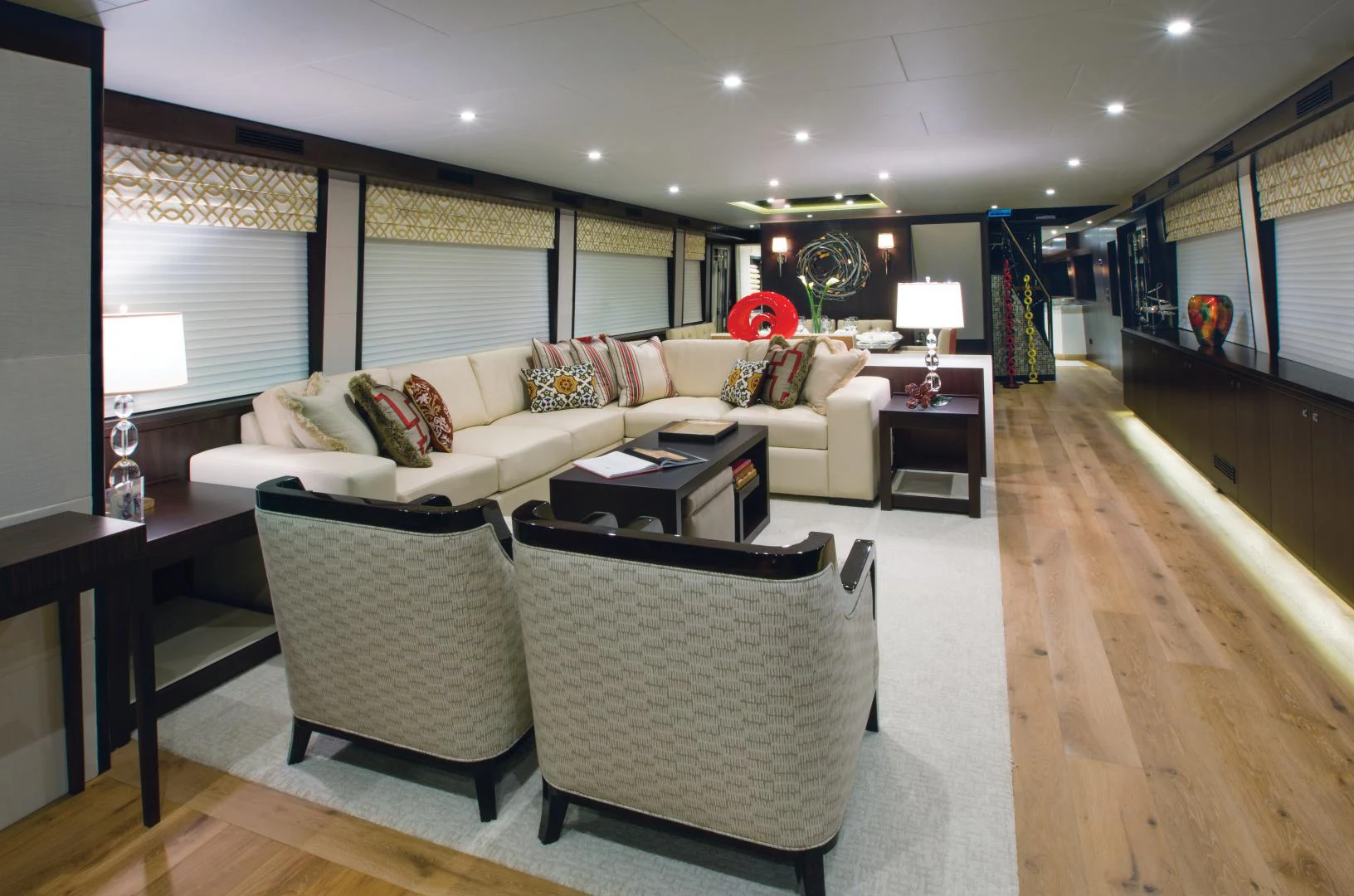 a living room with a couch and a table aboard 2021 HATTERAS 105RPH Yacht for Sale