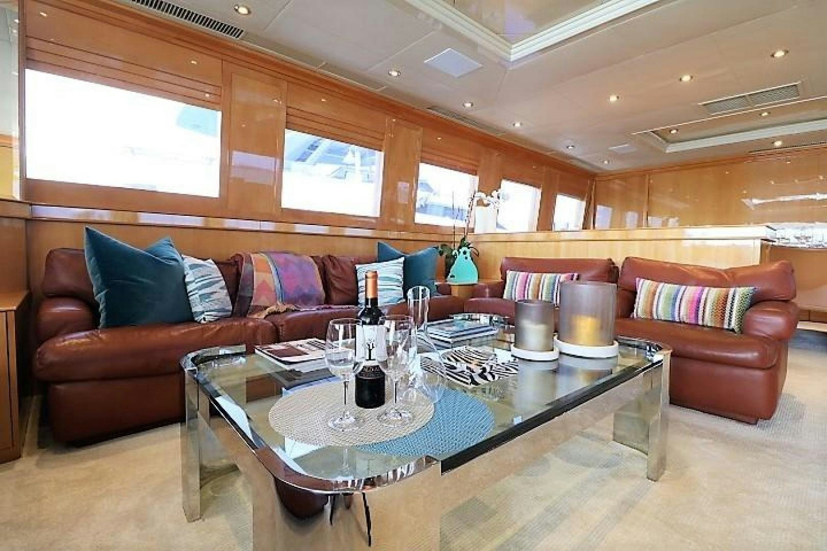 a large room with a table and couches aboard No Name Yacht for Sale