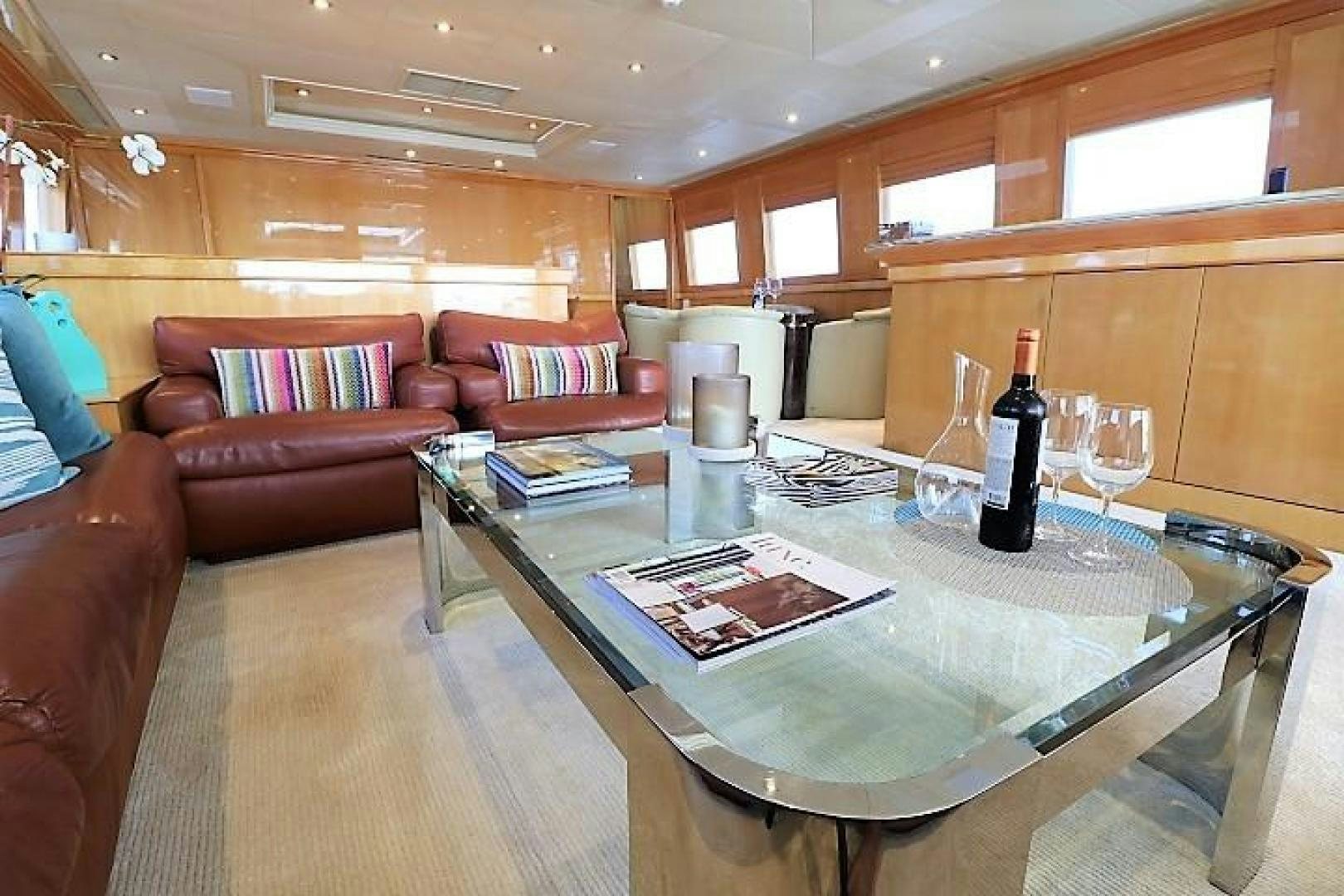 a large living room with a table and wine glasses aboard No Name Yacht for Sale