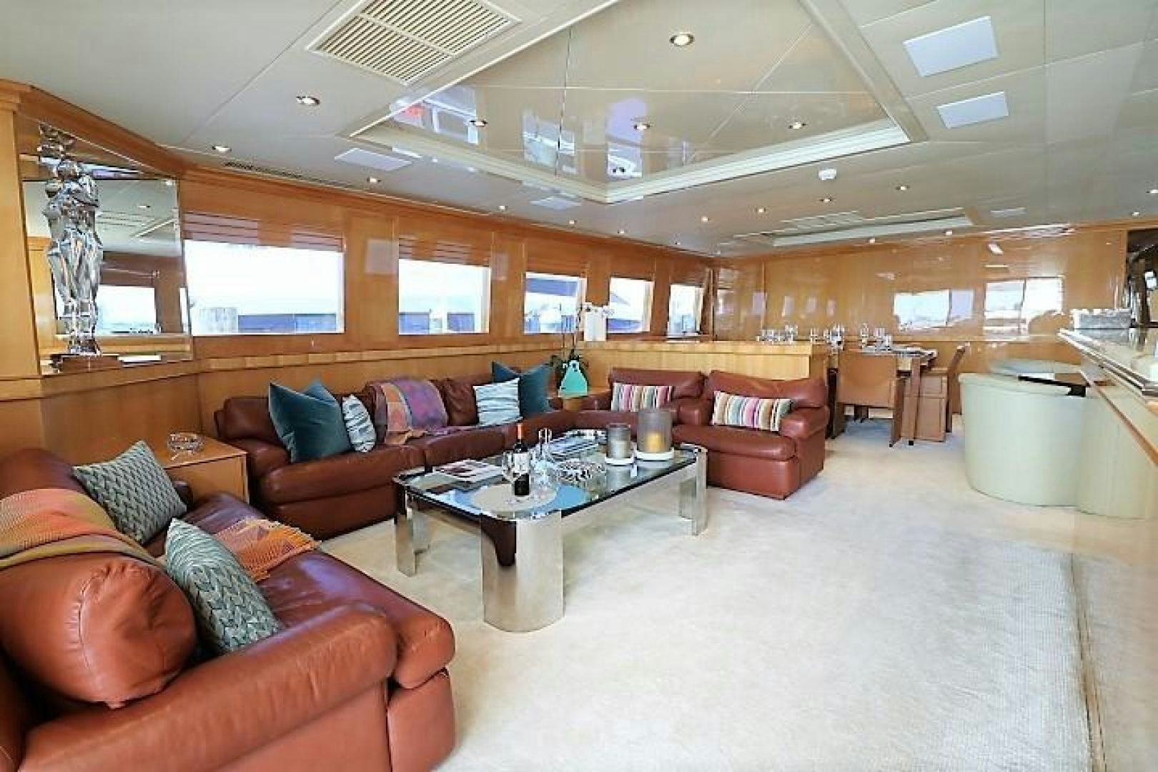 a living room with leather couches and a large mirror aboard No Name Yacht for Sale
