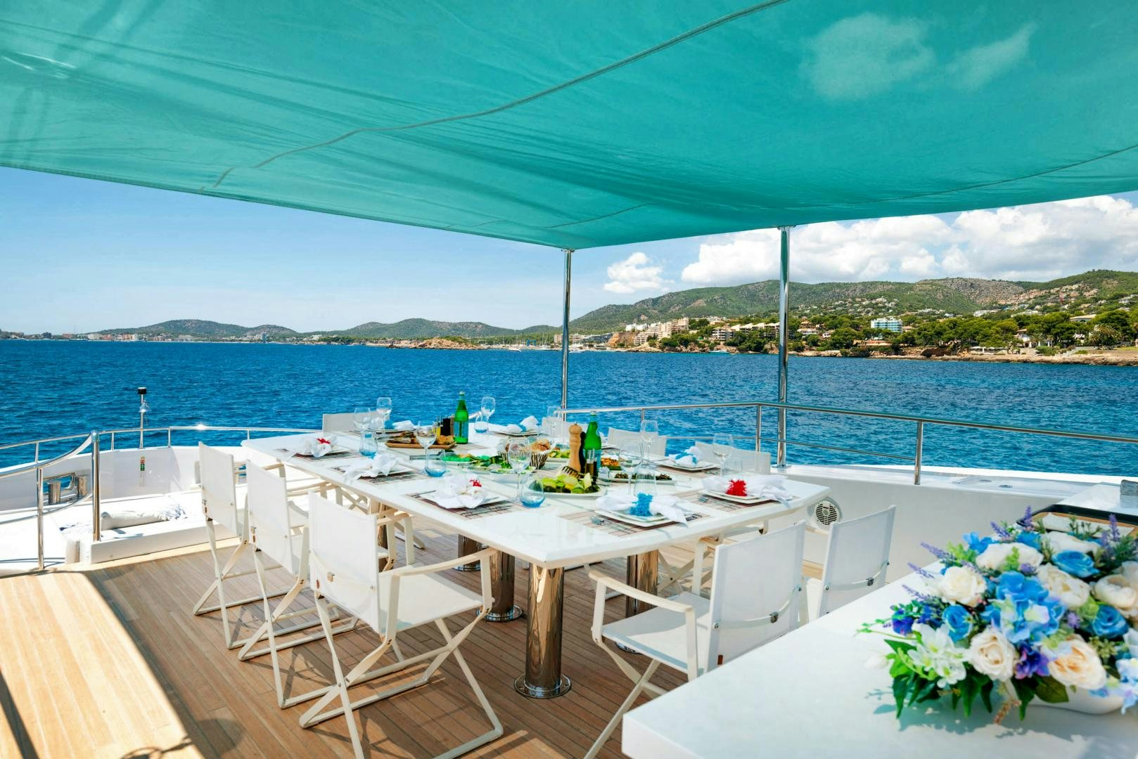 a table set for a meal on a deck overlooking the ocean aboard CURFEW II Yacht for Sale