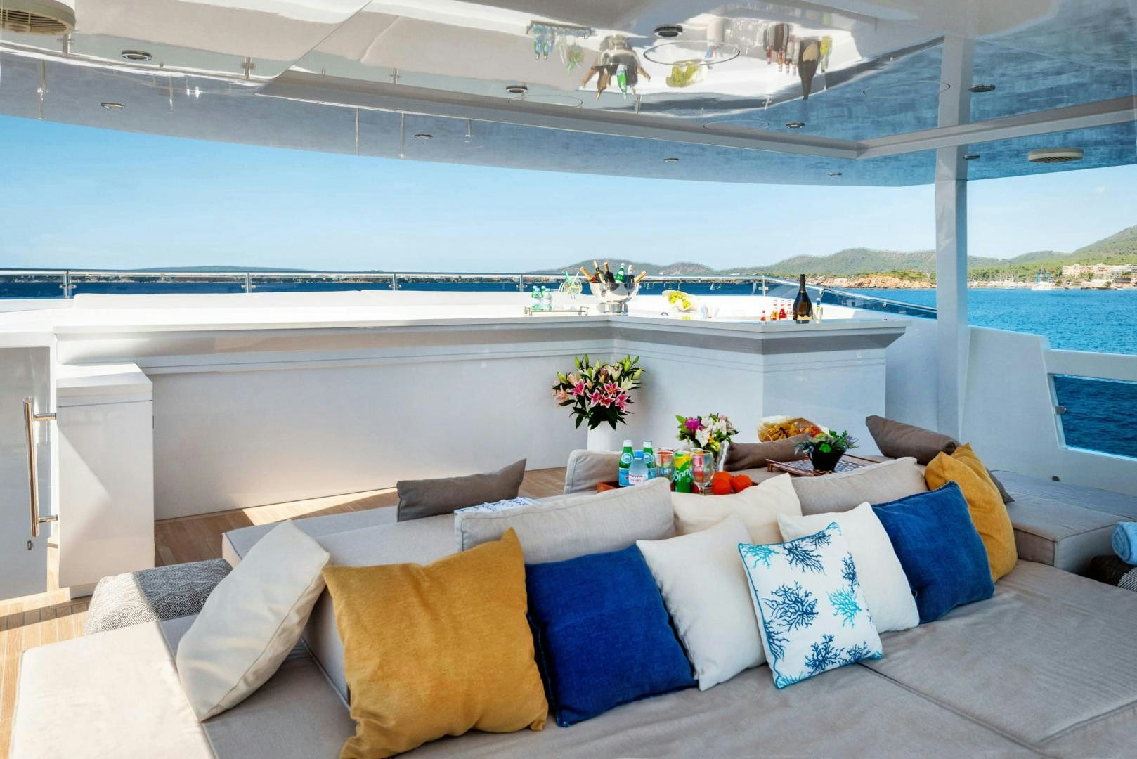 a large white lounge chair on a balcony overlooking a beach aboard CURFEW II Yacht for Sale