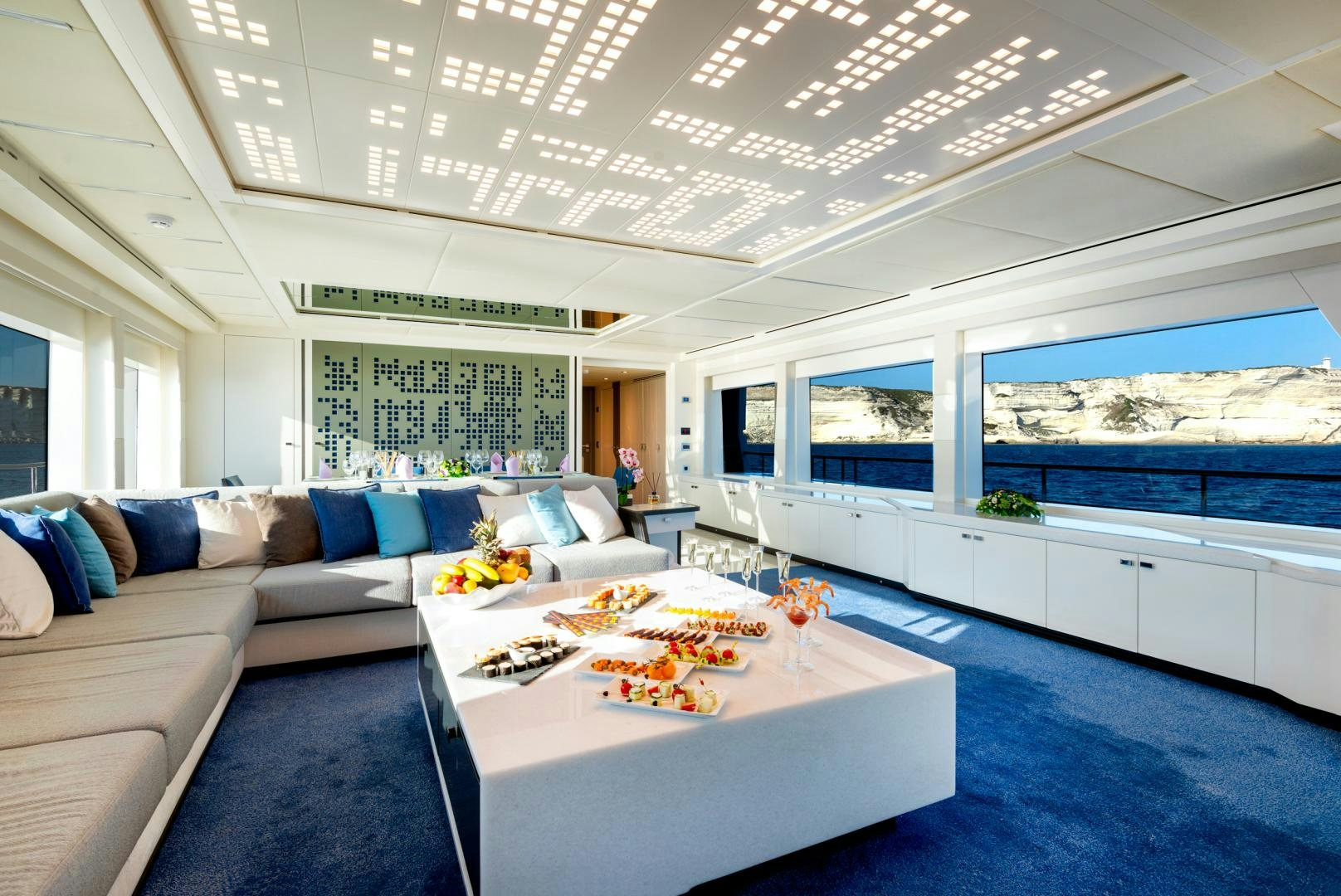 a living room with a large white table and a large window aboard CURFEW II Yacht for Sale